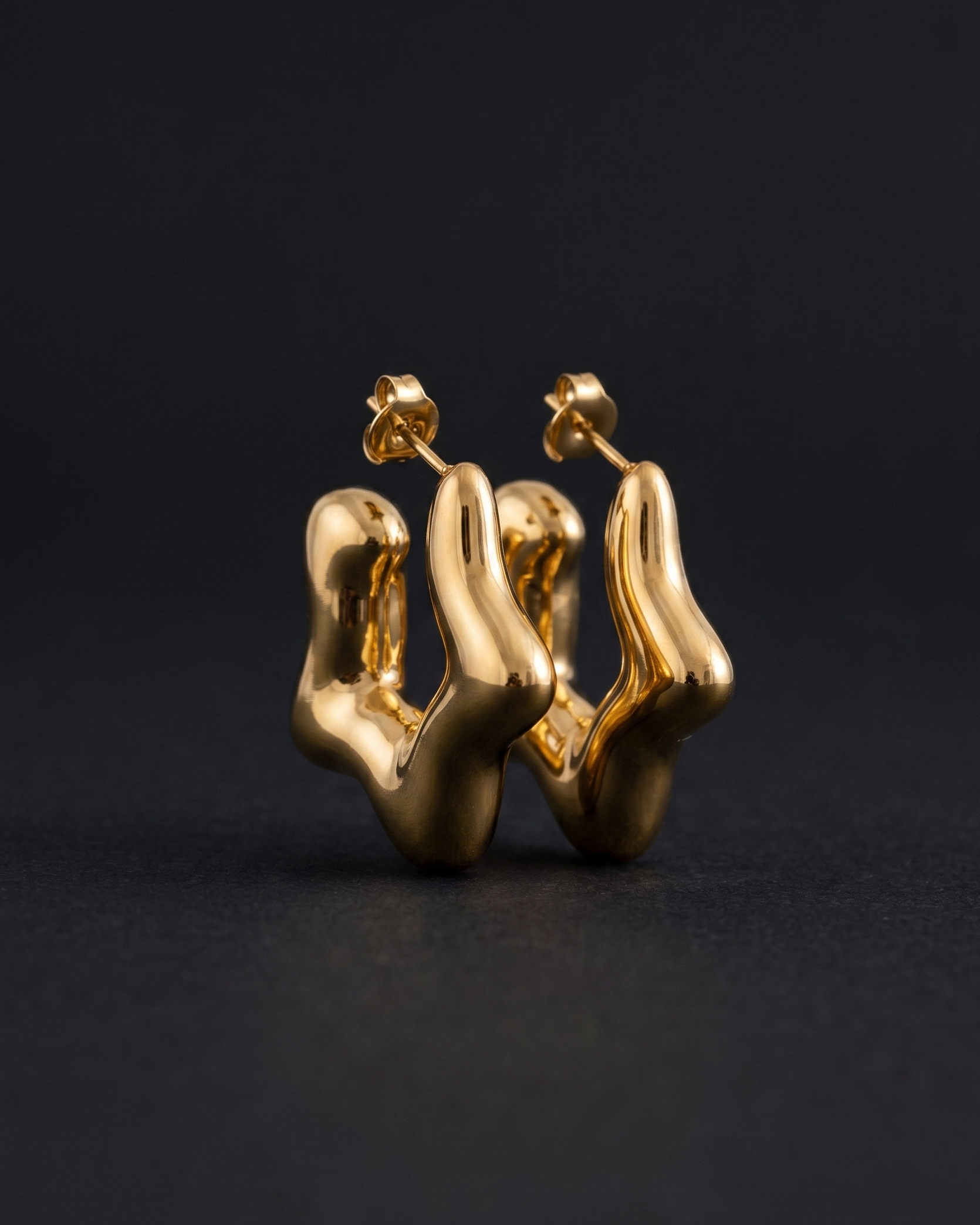 Gold earrings on a black background