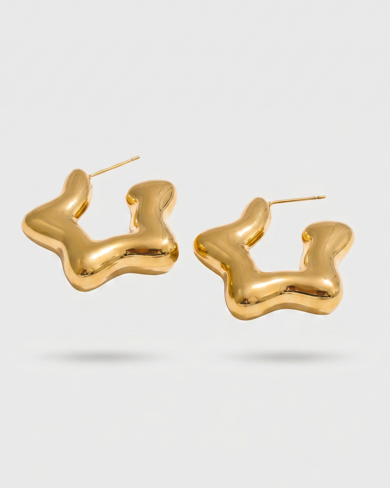 Gold hoop earrings on a light gray background