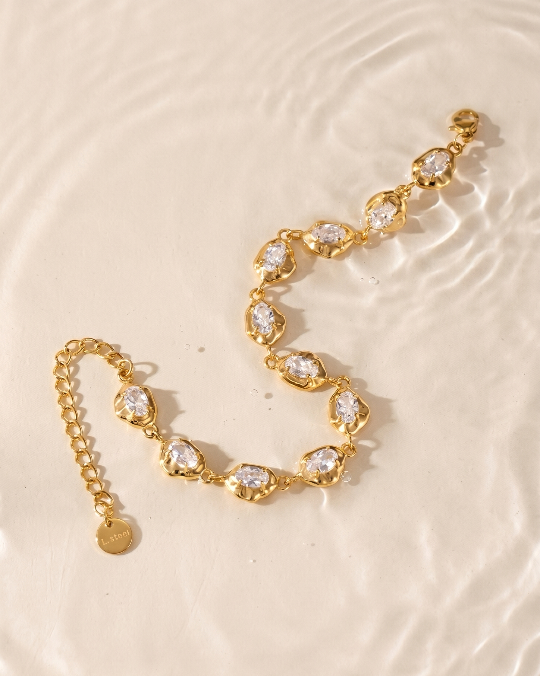 Gold bracelet with clear stones on a beige surface
