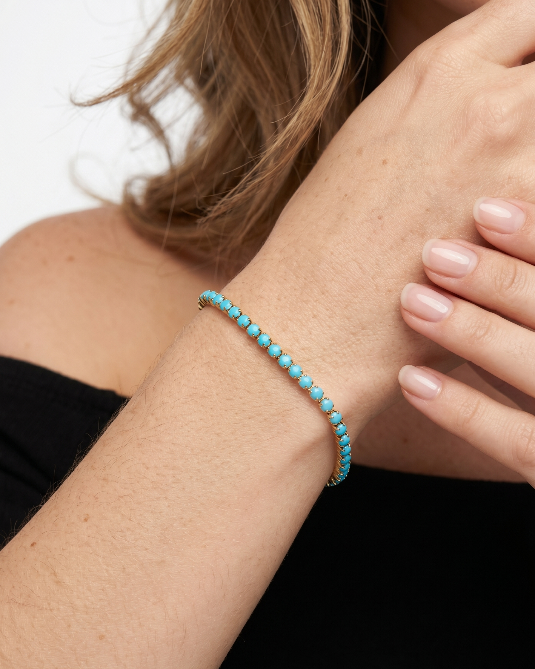 Turquoise beaded bracelet on a wrist with a blurred background