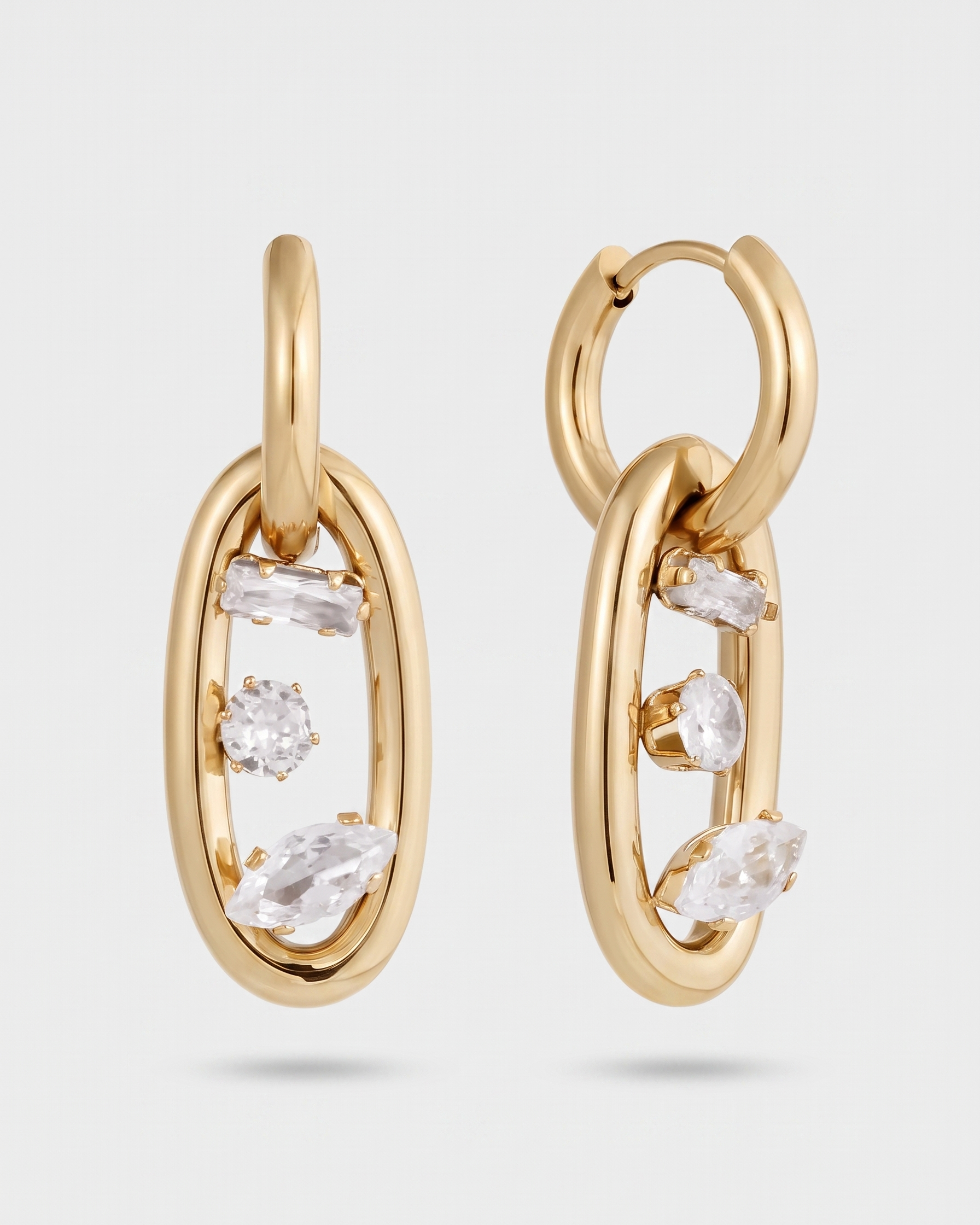 Gold hoop earrings with clear gemstones on a light gray background