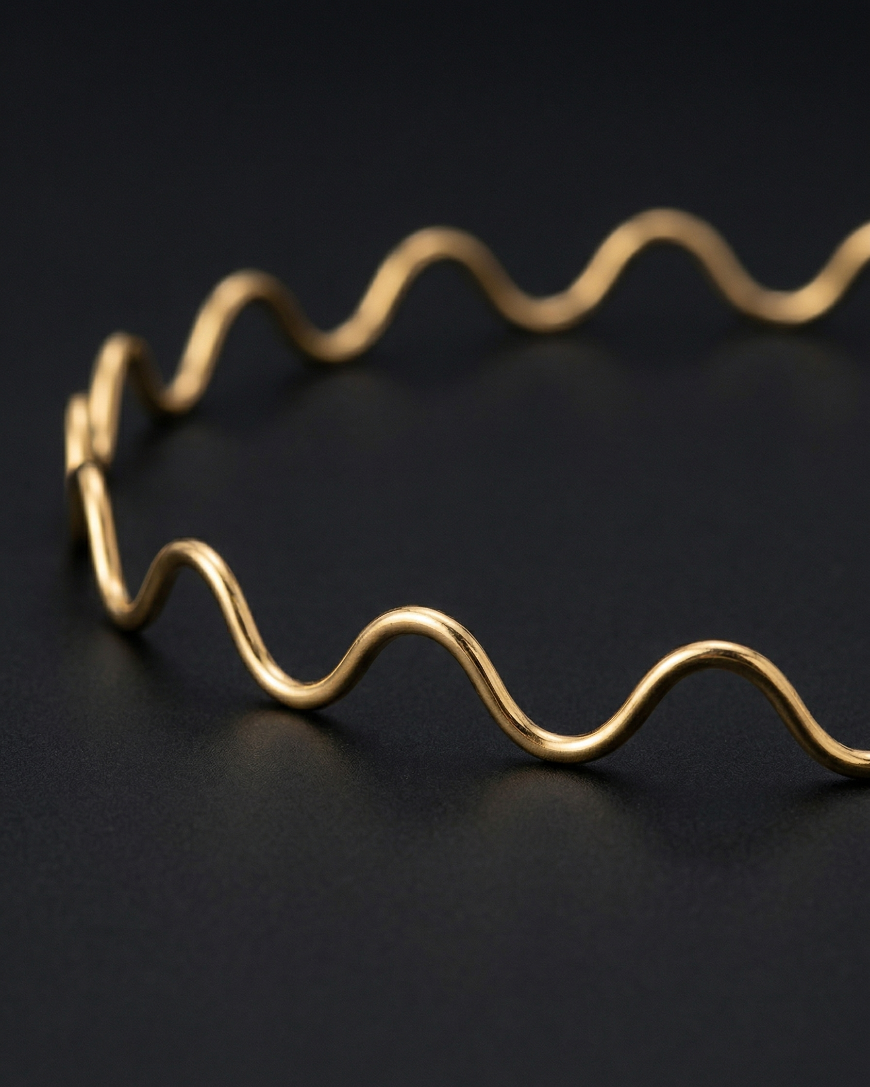 Gold headband with wavy design on a black background