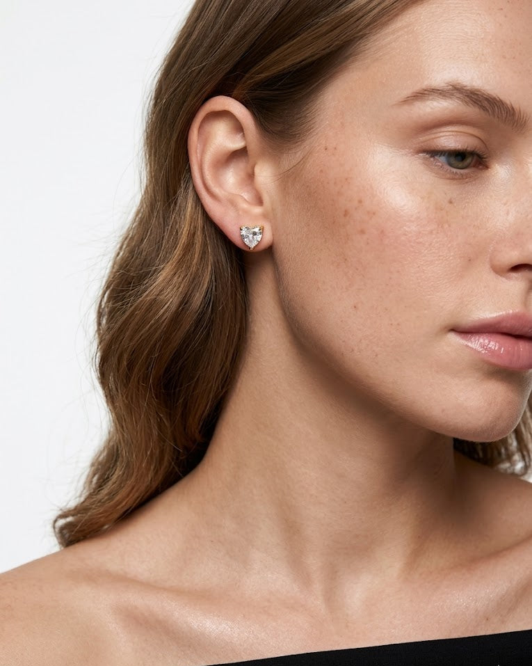 Close-up of a woman wearing a diamond earring on a plain background