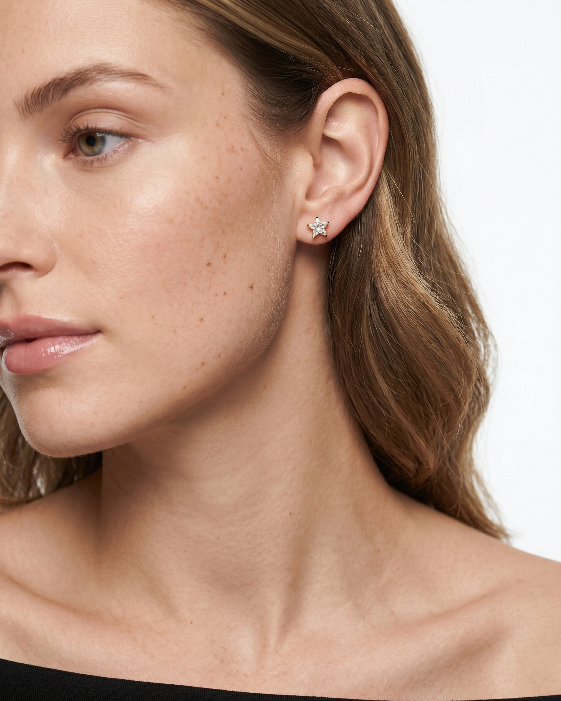 Close-up of a woman wearing a diamond earring on a white background