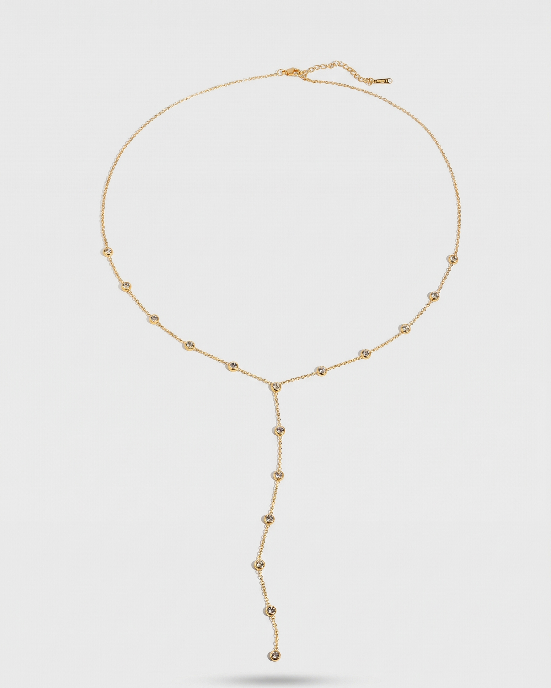 Gold necklace on a light gray background