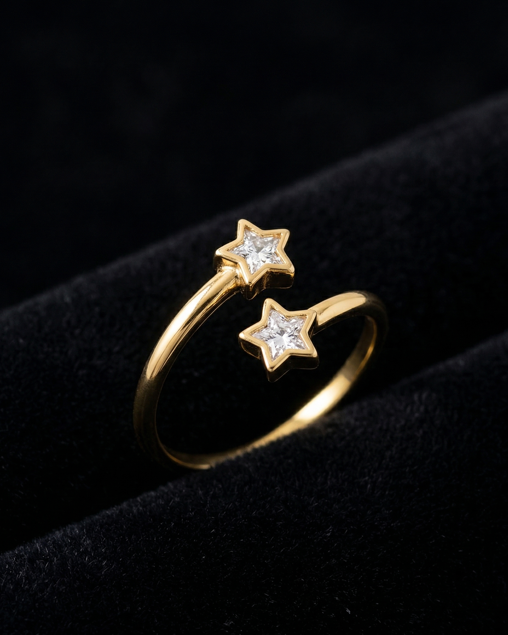 Gold ring with star-shaped gemstones on a black background