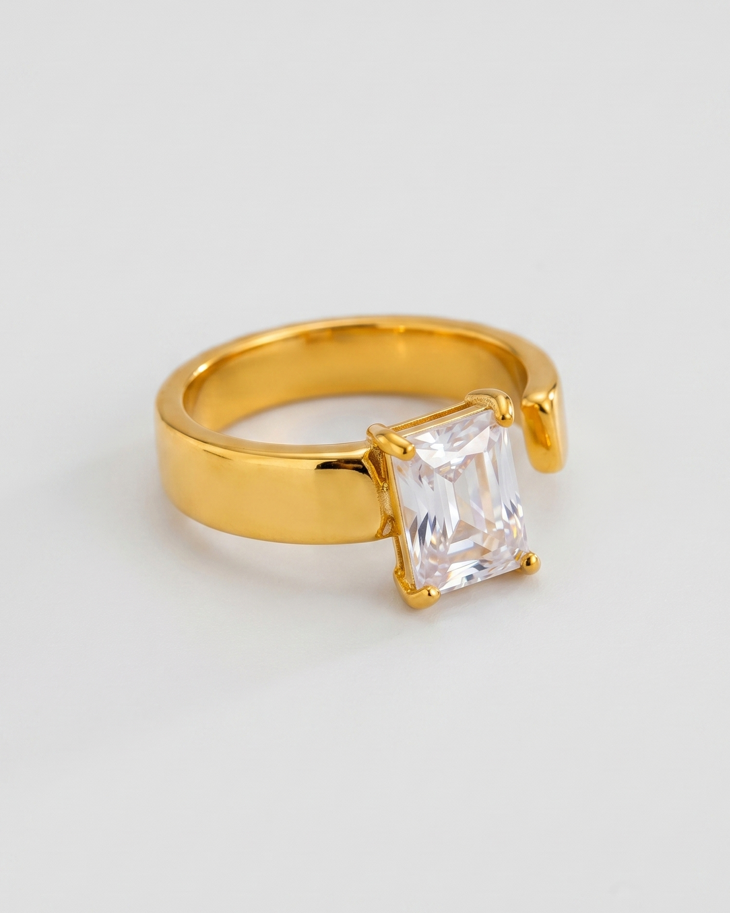 Gold ring with a clear gemstone on a white background