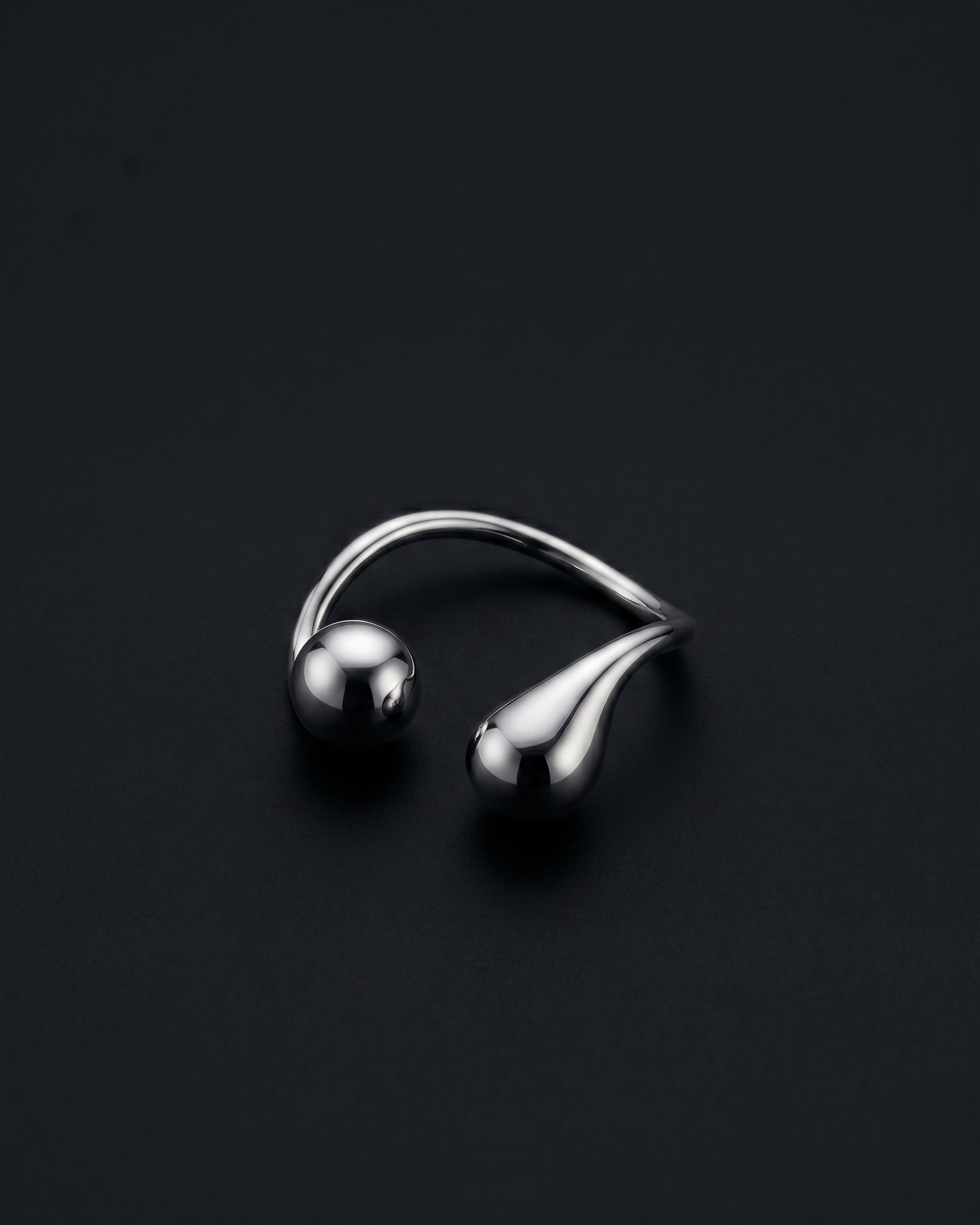 Silver earring on a black background