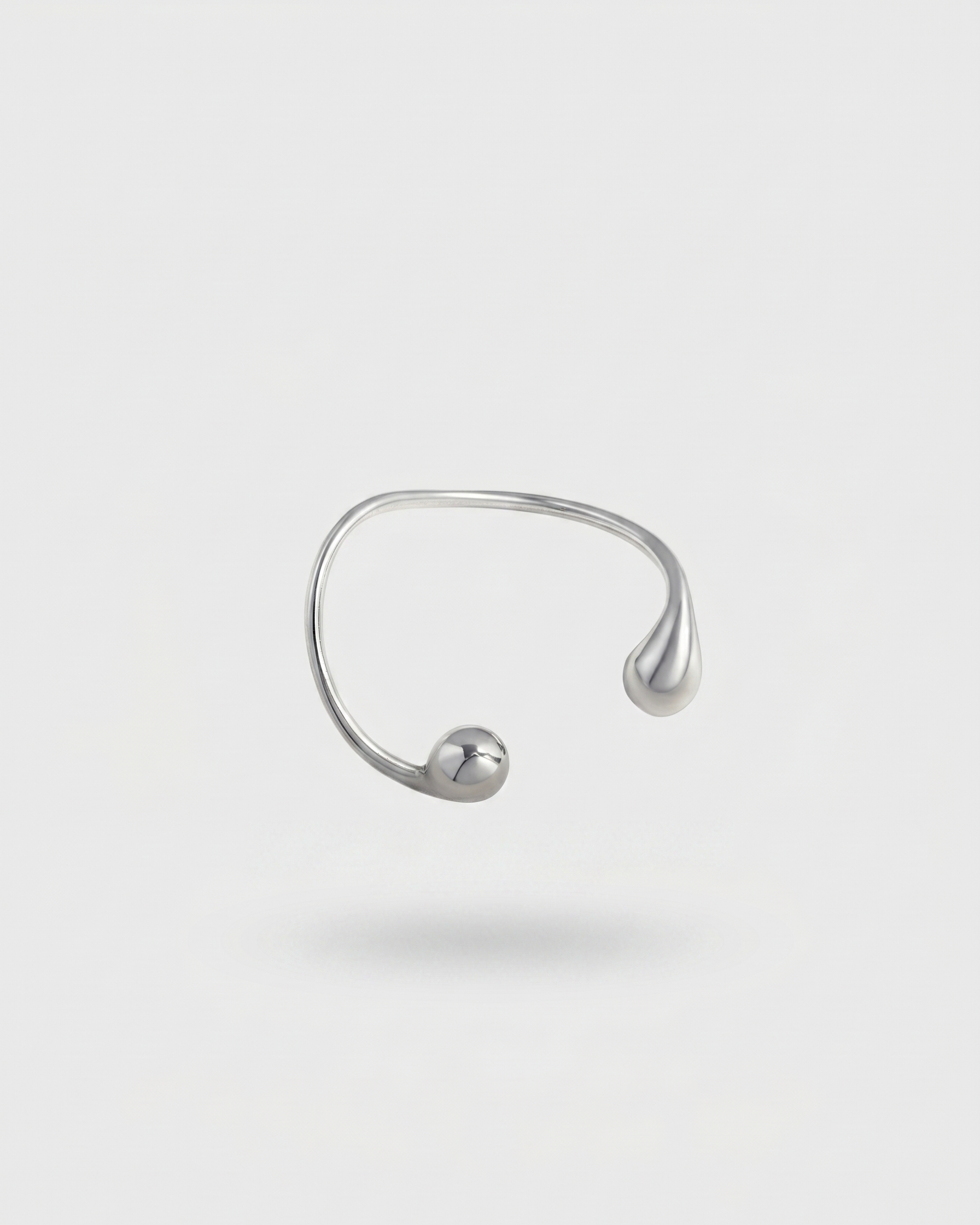 Silver open ring on a light gray background