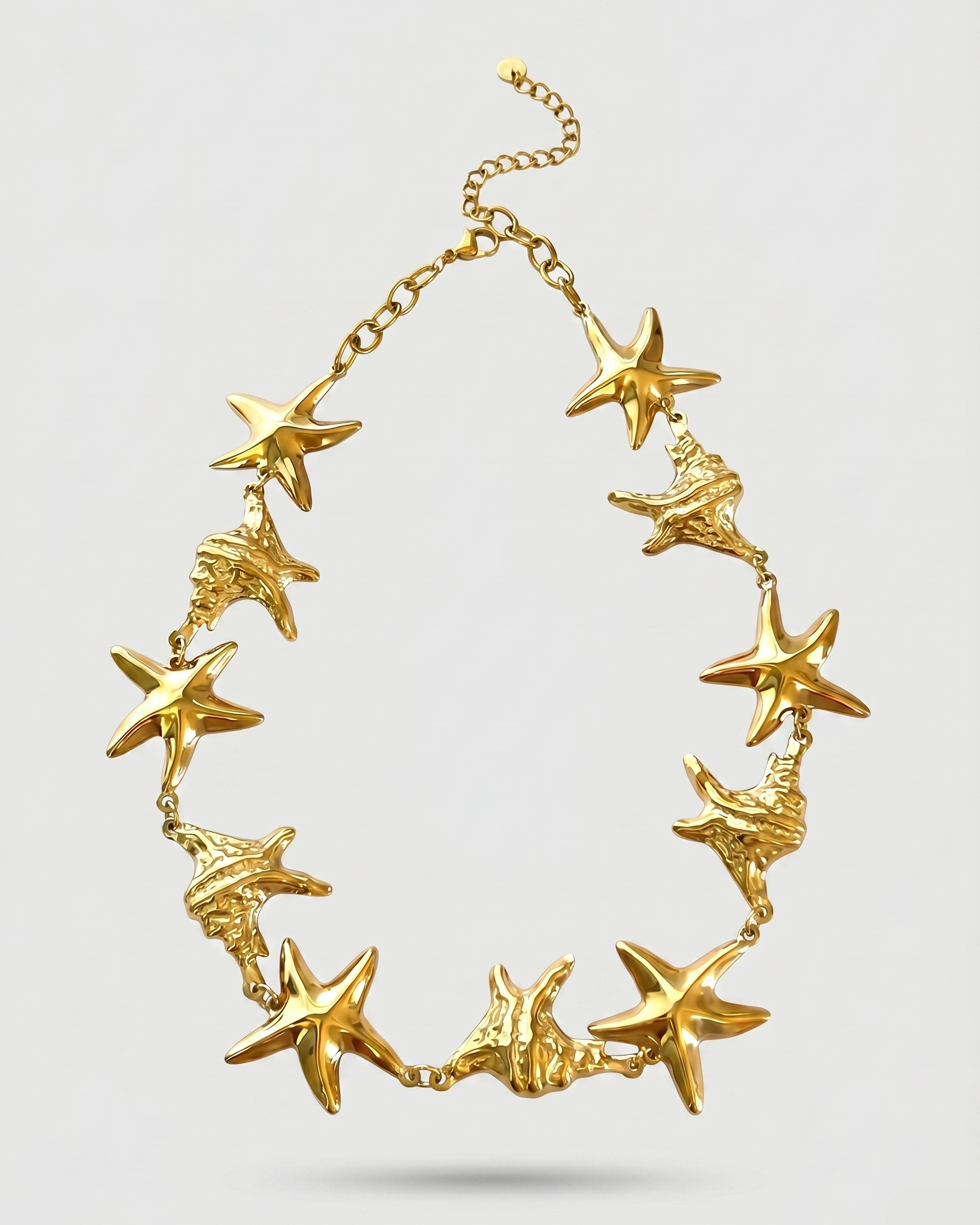 Gold necklace with starfish designs on a light gray background
