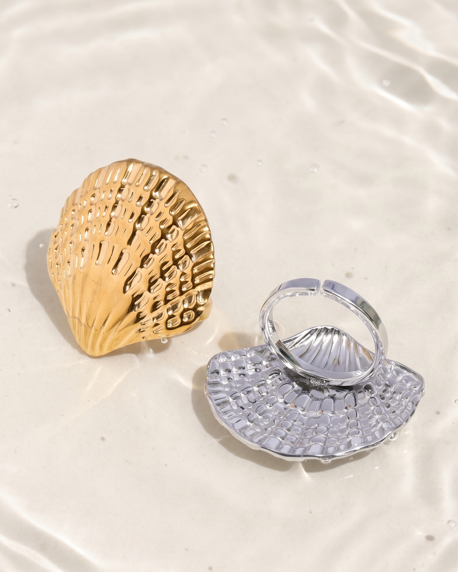 Gold and silver shell-shaped jewelry on a light background