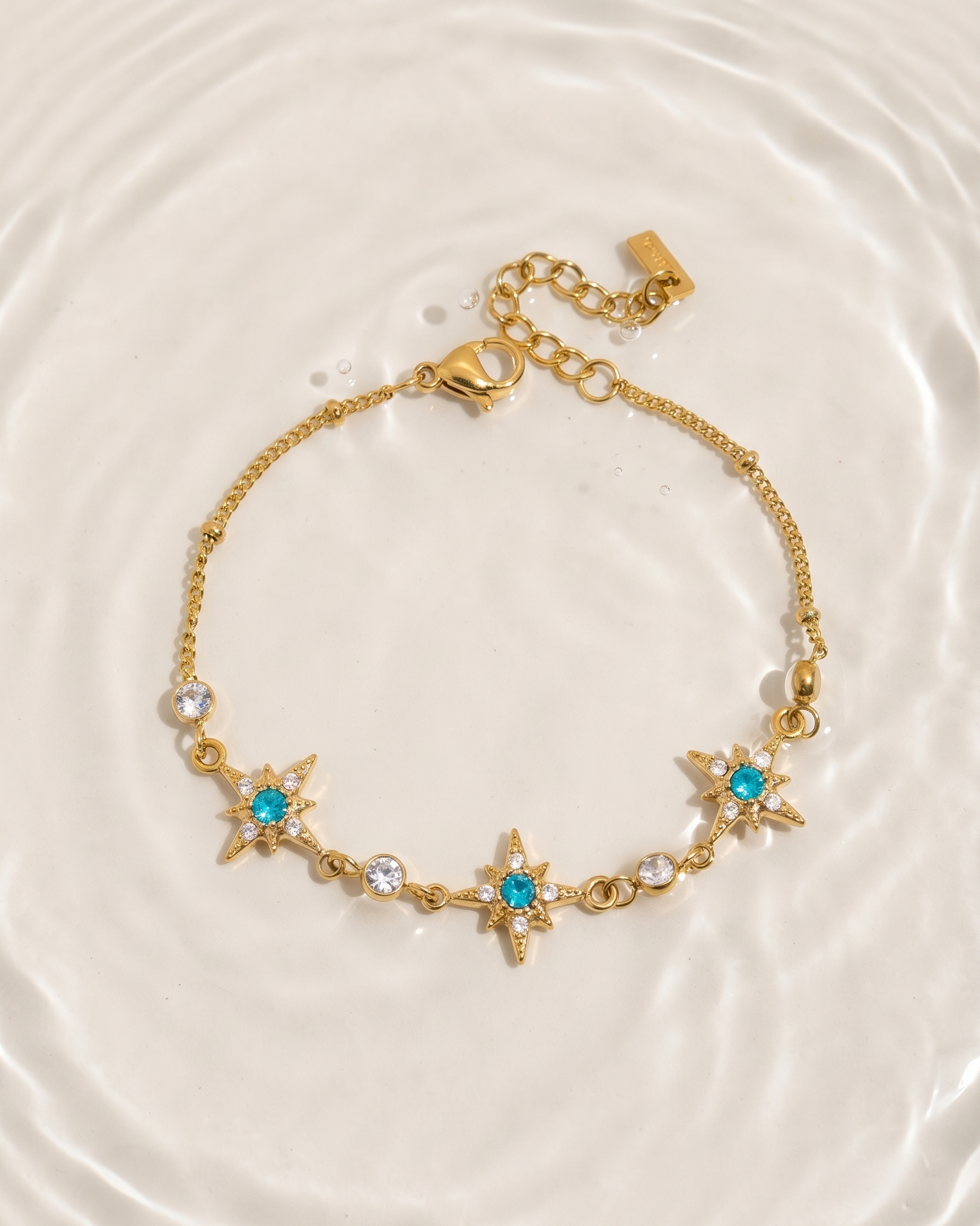 Gold bracelet with star-shaped charms on a light background