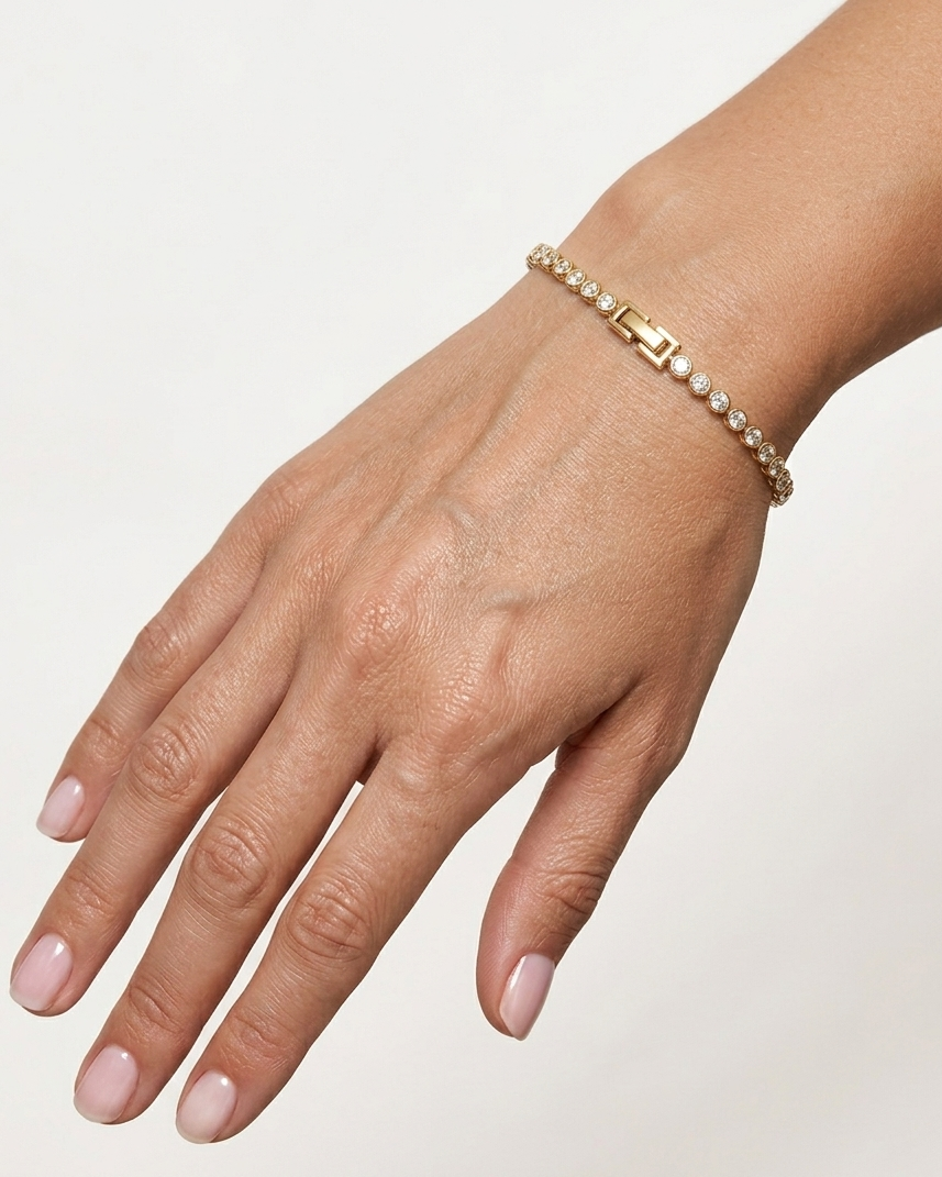 Hand wearing a delicate bracelet on a light background