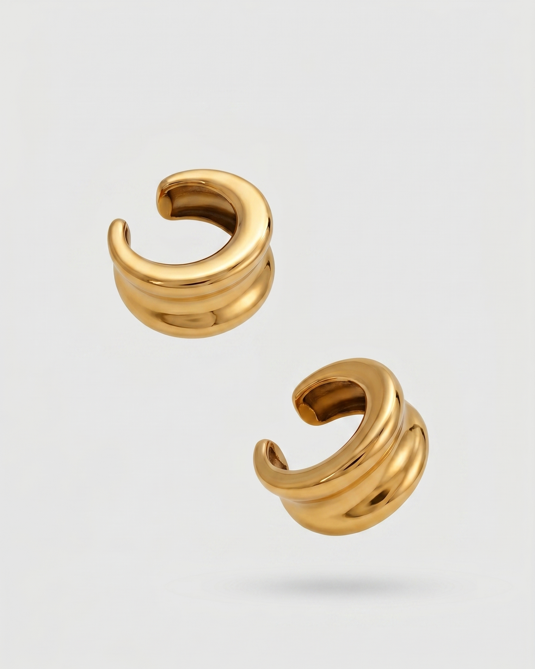 Pair of gold hoop earrings on a light gray background