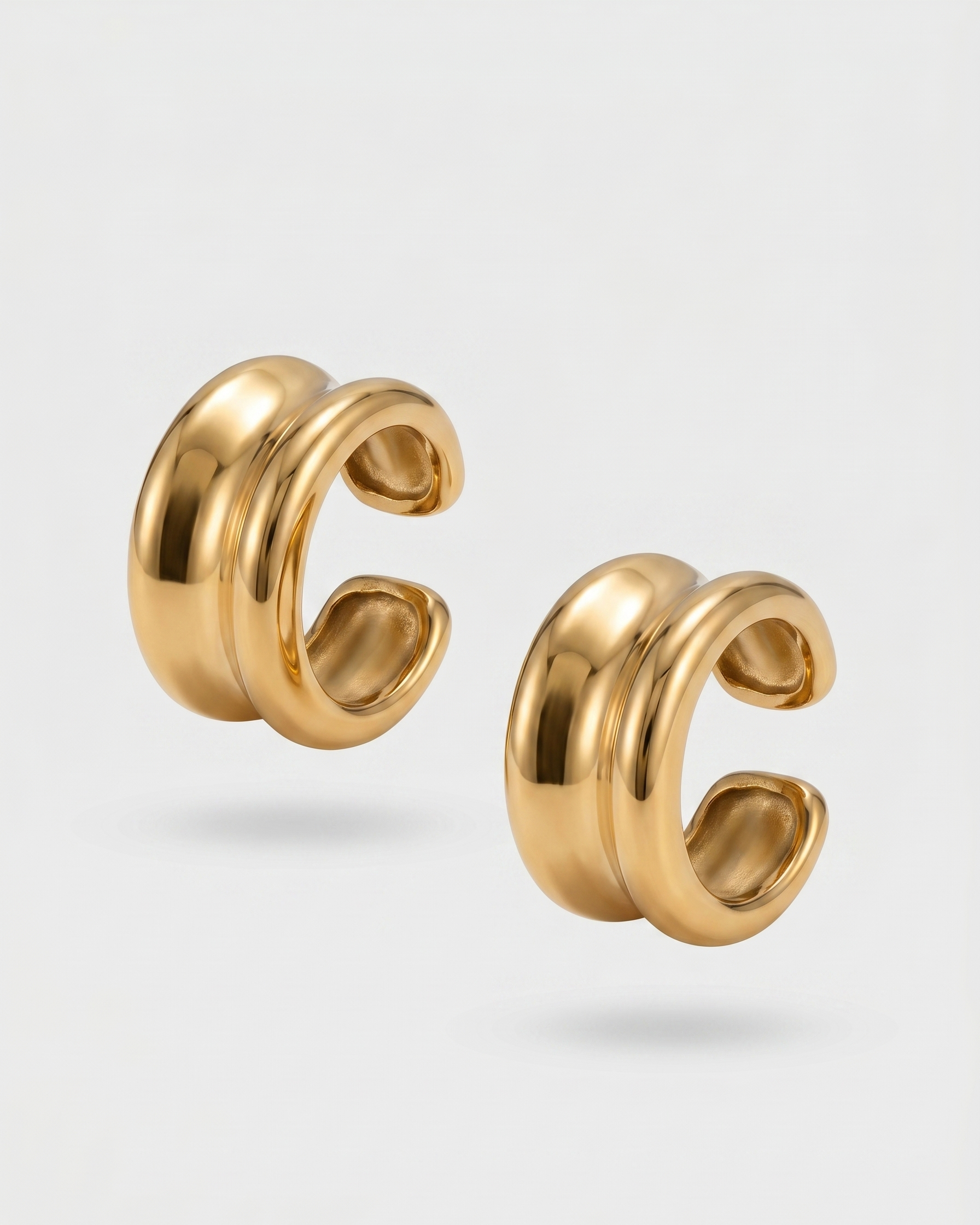Pair of gold hoop earrings on a light gray background