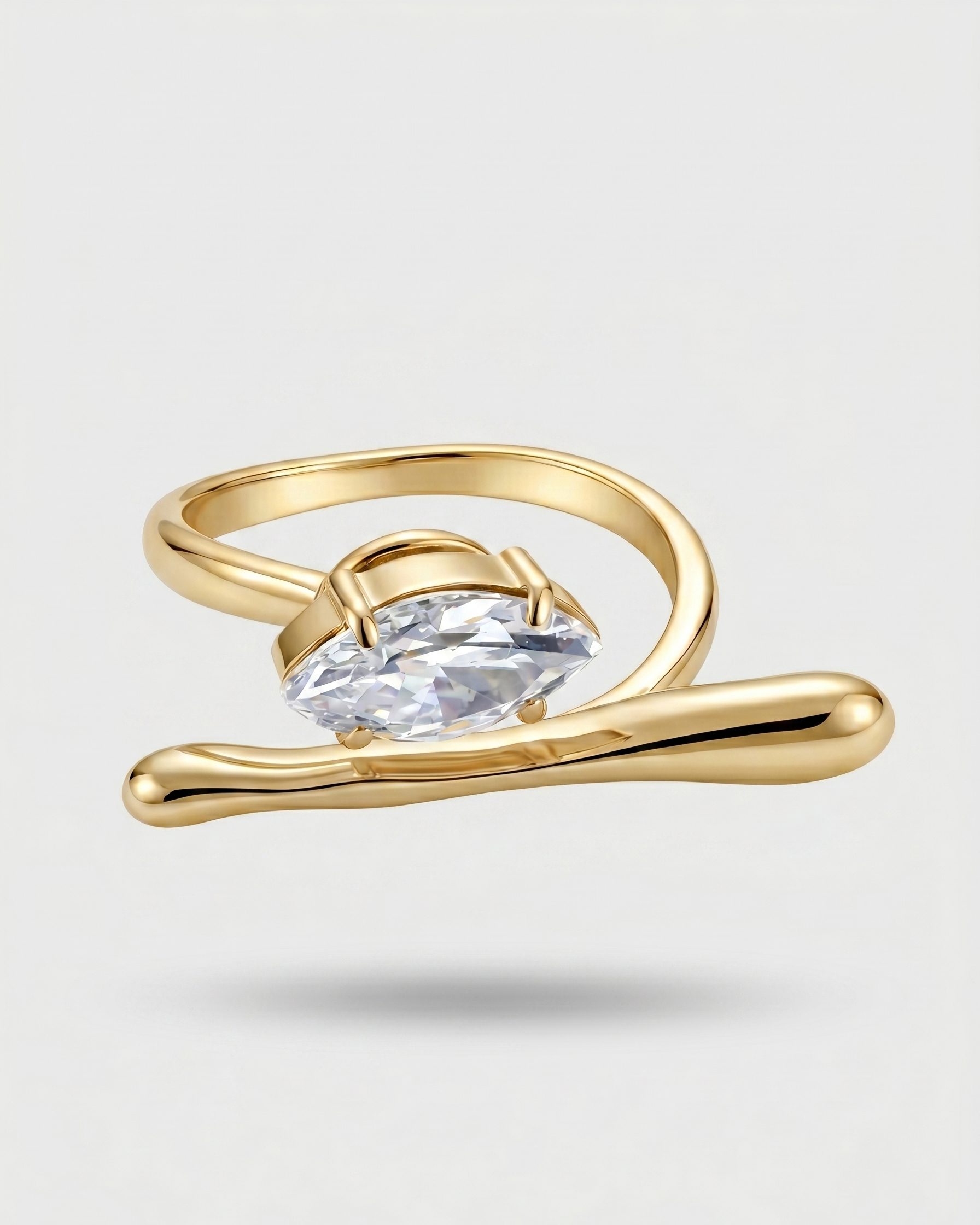 Gold ring with a clear gemstone on a light gray background