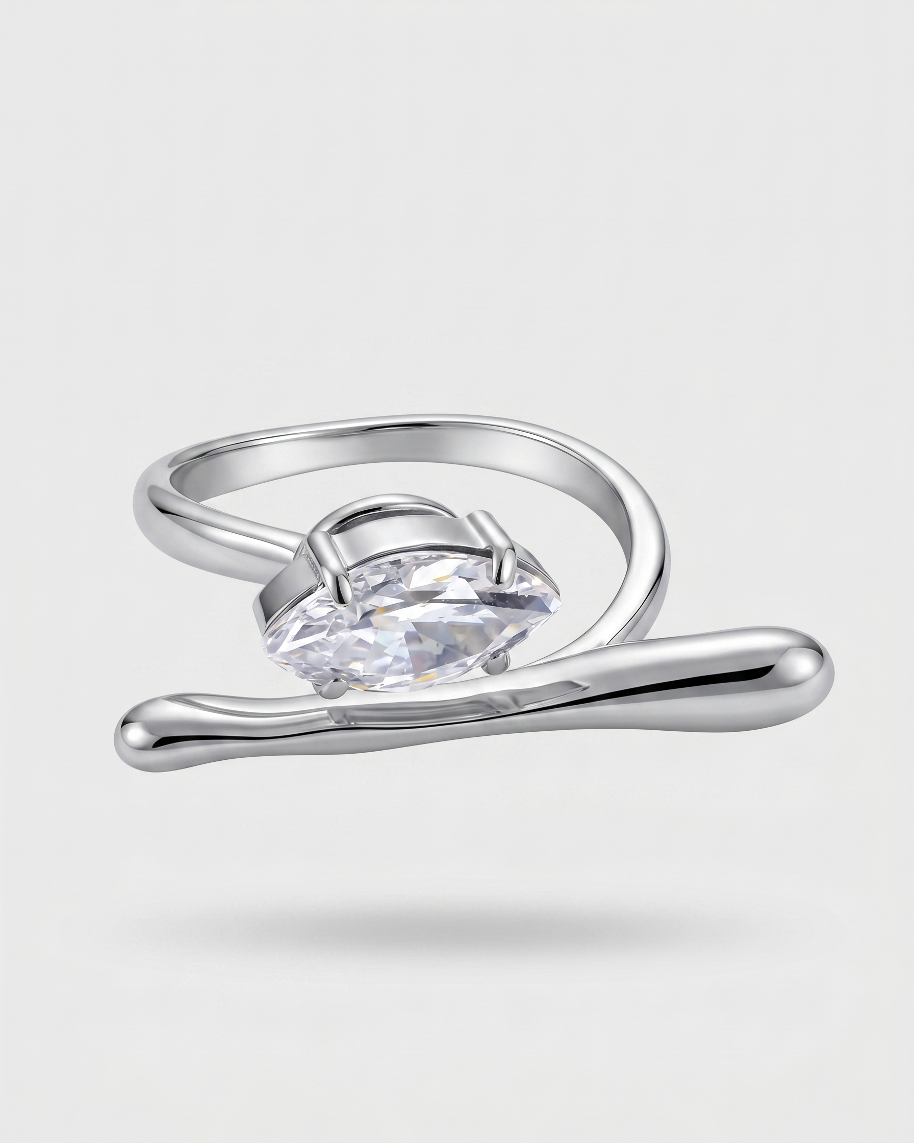 Silver ring with a clear gemstone on a light gray background