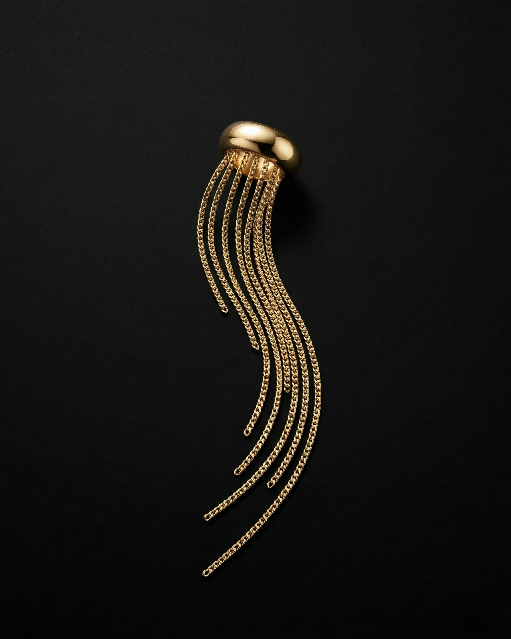 Gold earring with fringed design on a black background