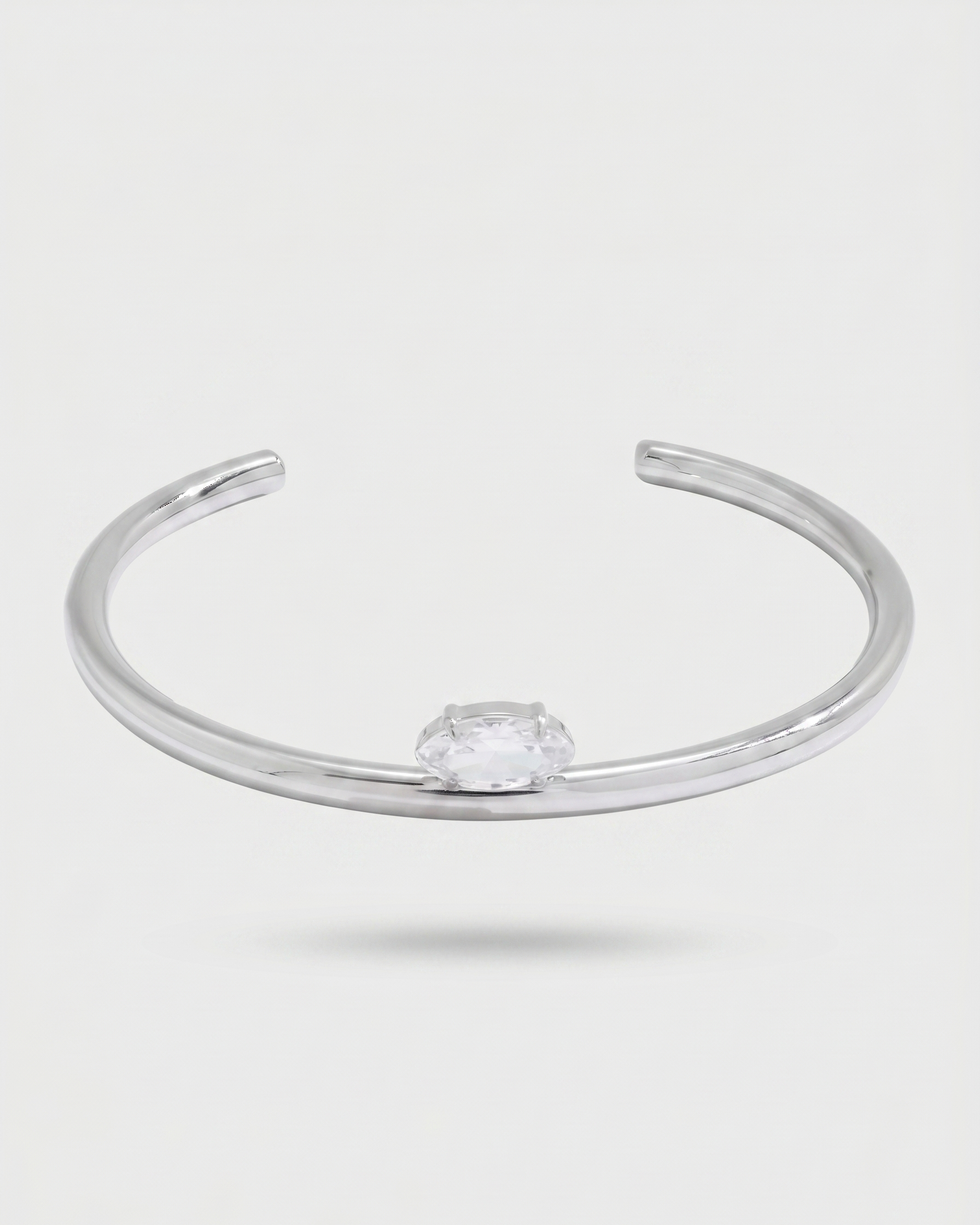 Silver bracelet with a clear gemstone on a light gray background