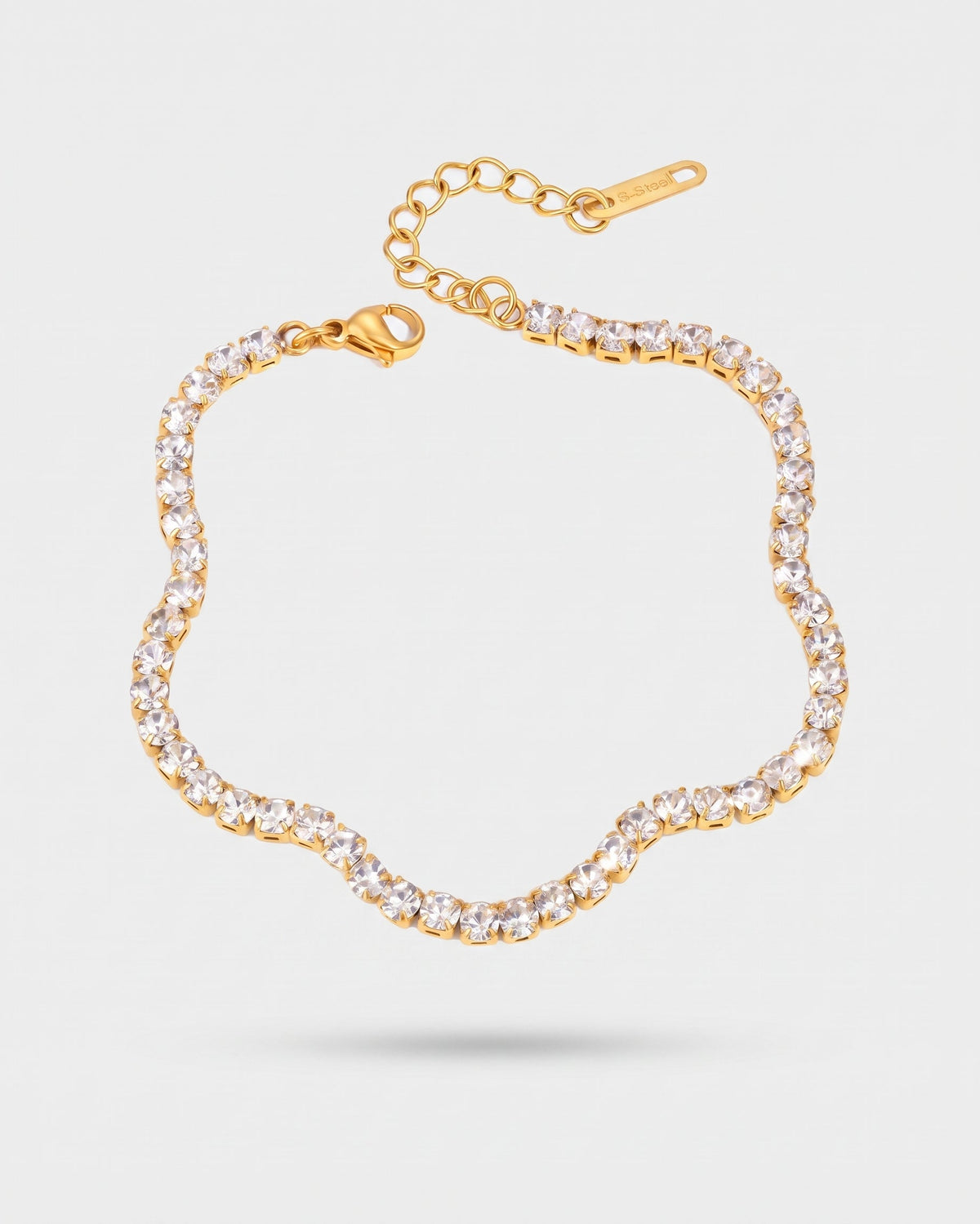A gold-toned flower-shaped bracelet paved with clear rhinestones, featuring a lobster clasp and an adjustable chain extender, shown on a light gray background.