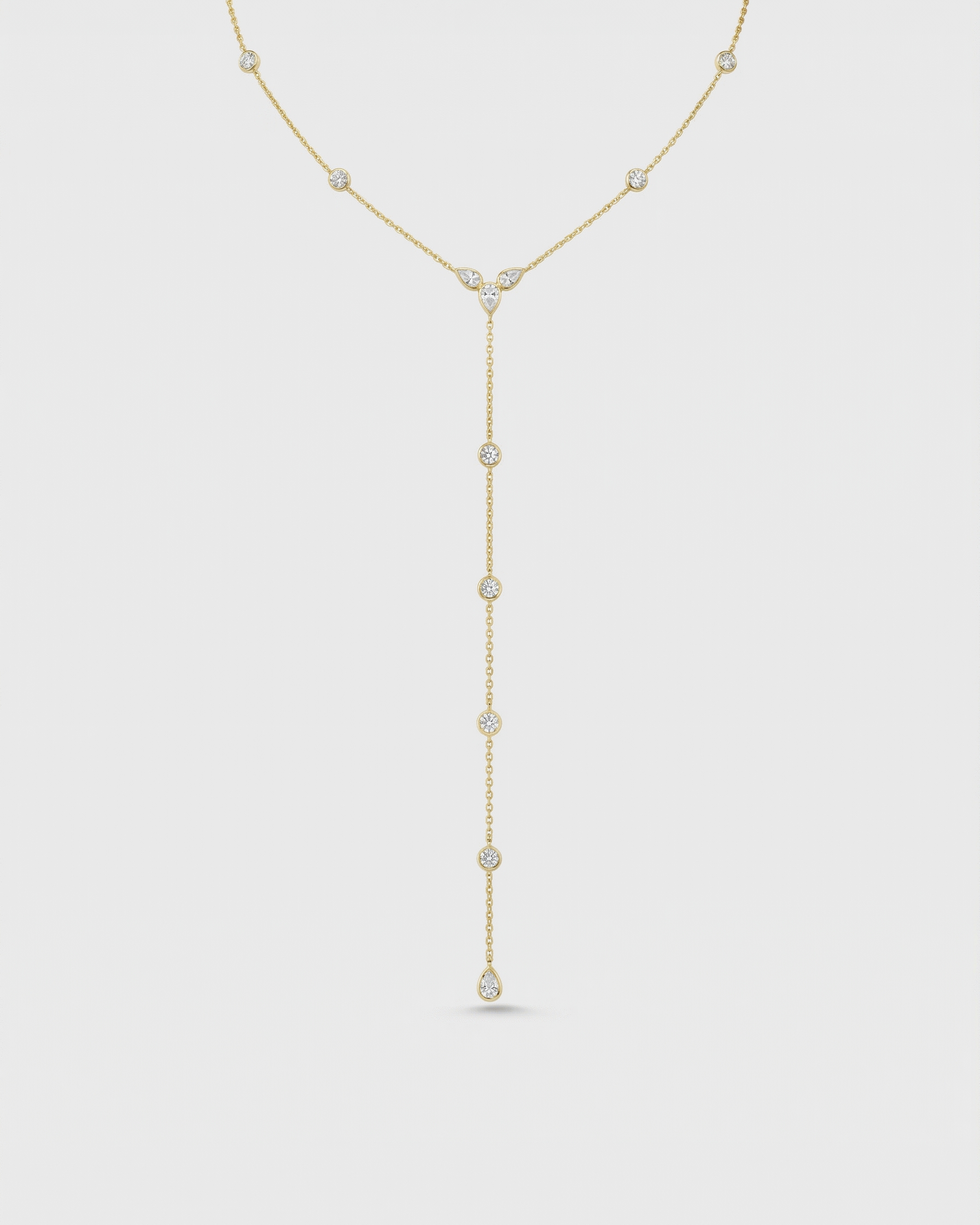 Gold necklace with small diamonds on a light gray background