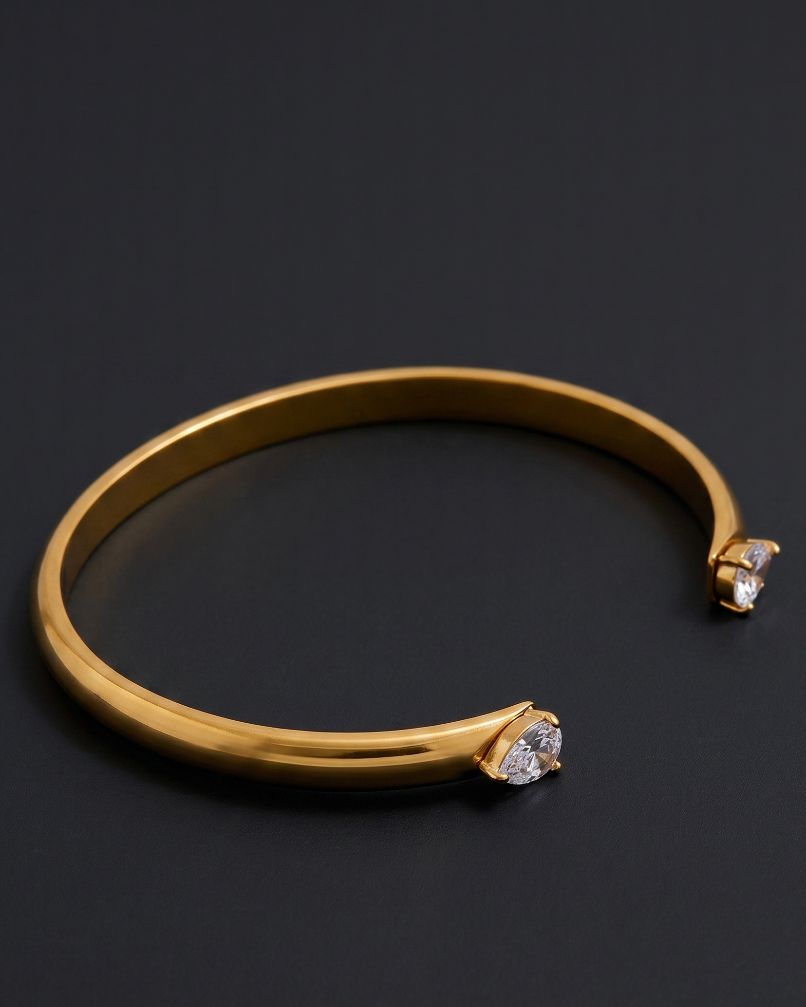 Gold bracelet with diamond accents on a dark background