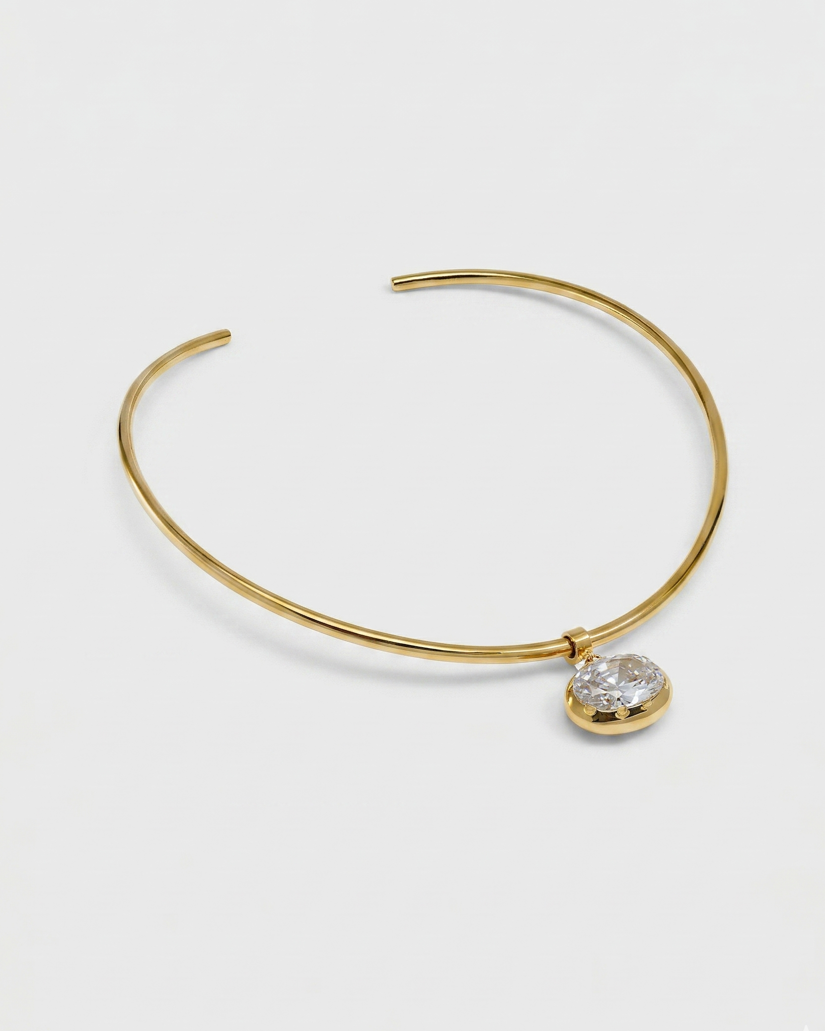 Gold bracelet with a heart-shaped diamond on a white background