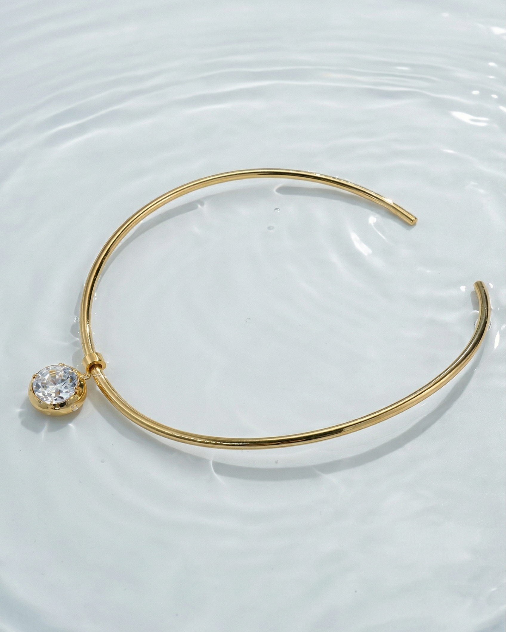 Gold bracelet with a diamond on a white background