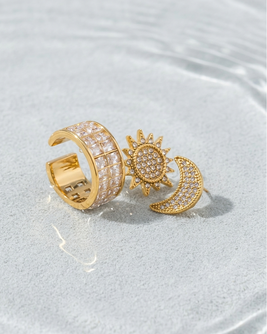 Gold ring with sun and moon design on a light gray background