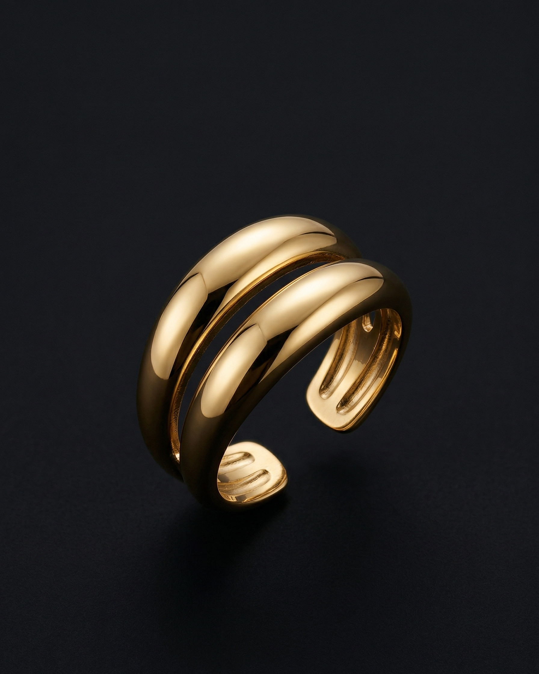 Gold ring with a ribbed design on a black background