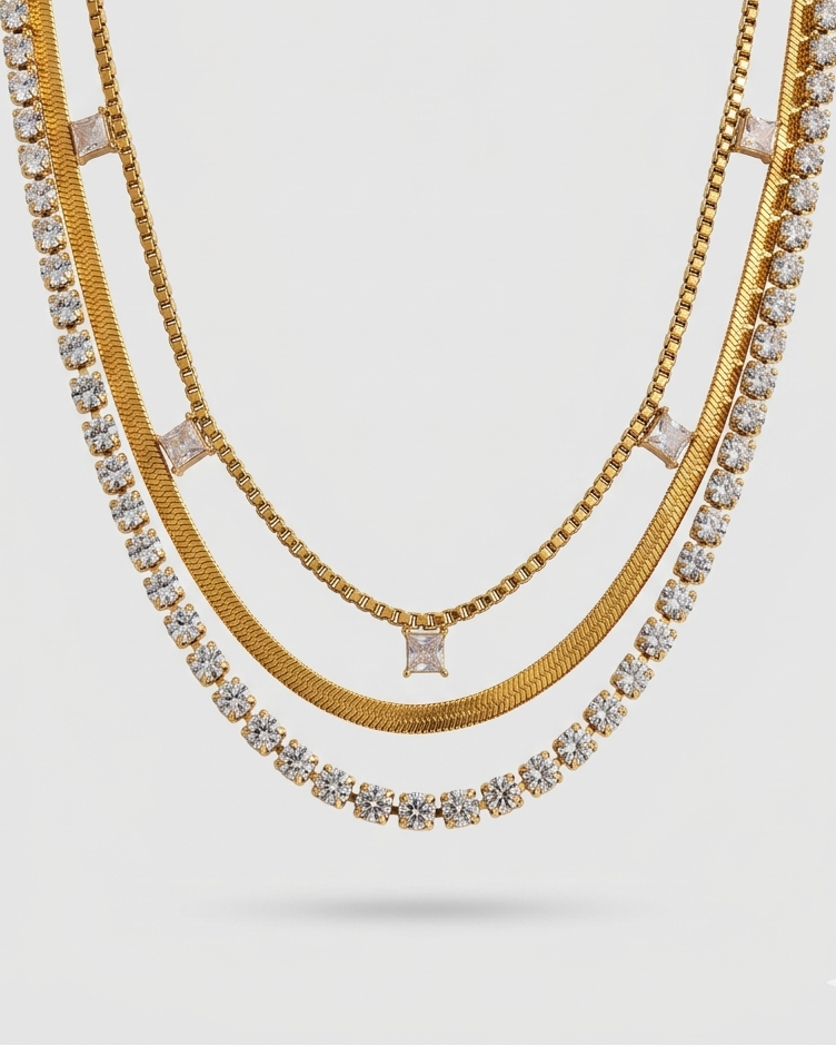Gold necklaces with embedded stones on a light gray background