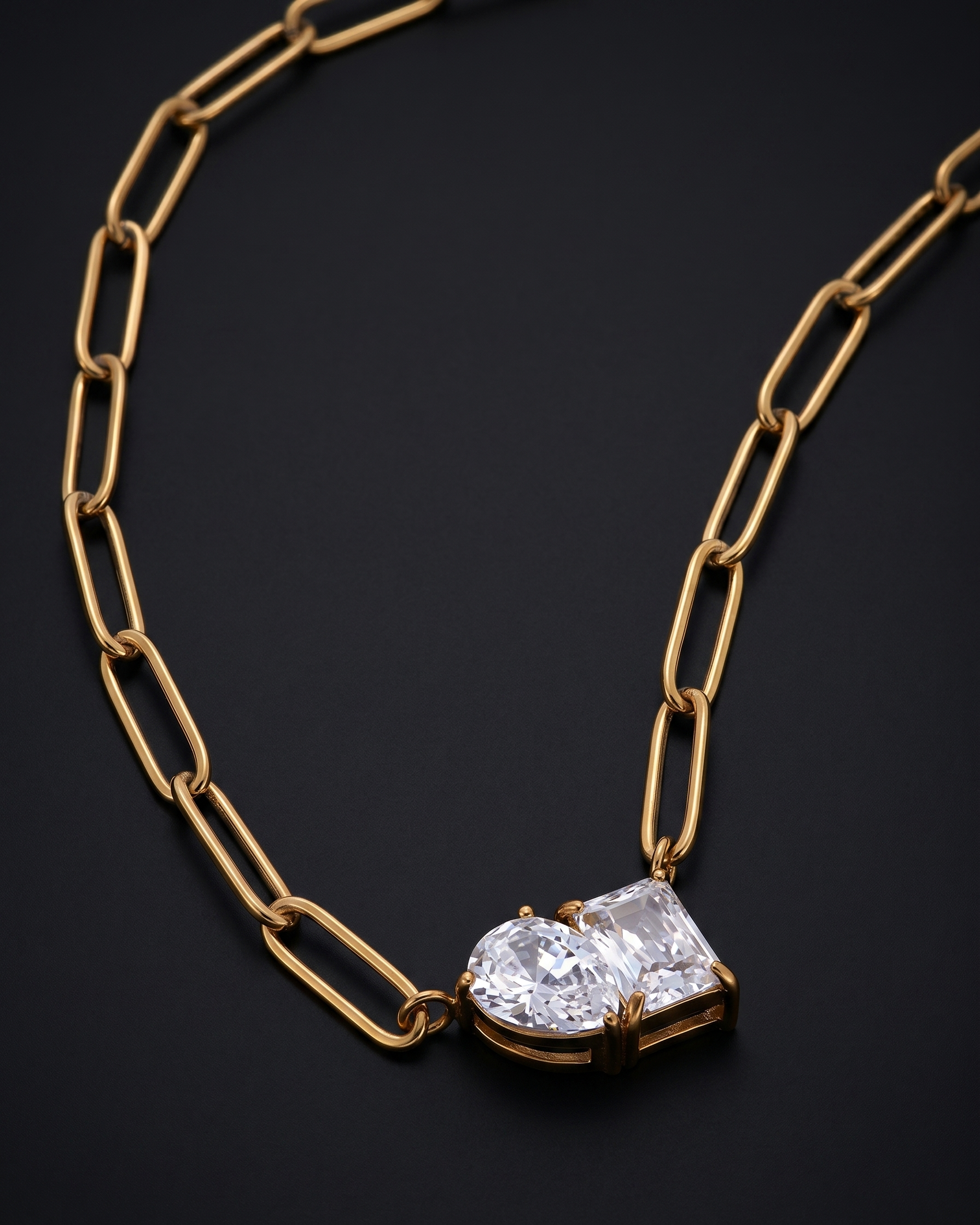 Gold chain necklace with a diamond pendant on a black background
