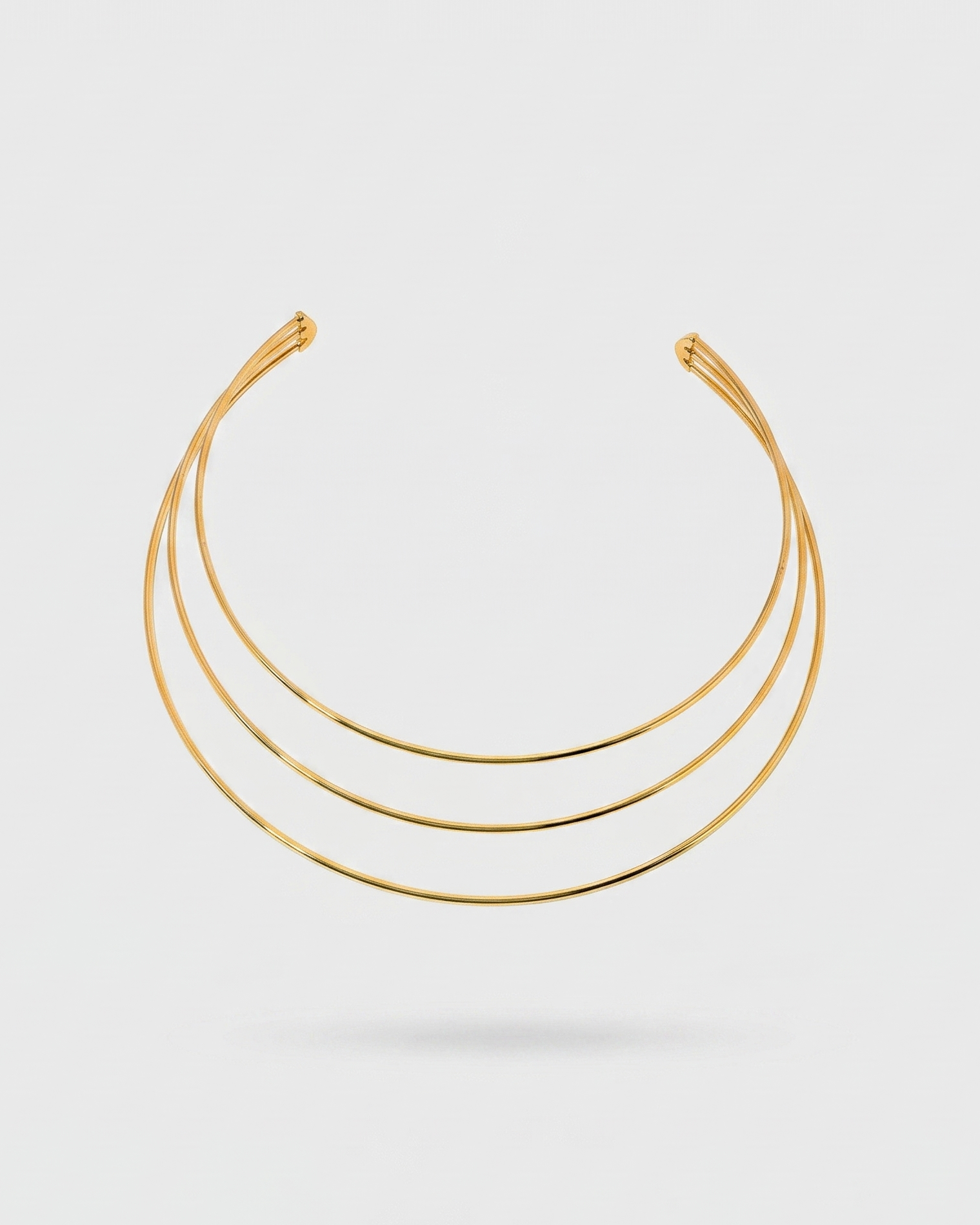 Set of three gold necklaces on a white background