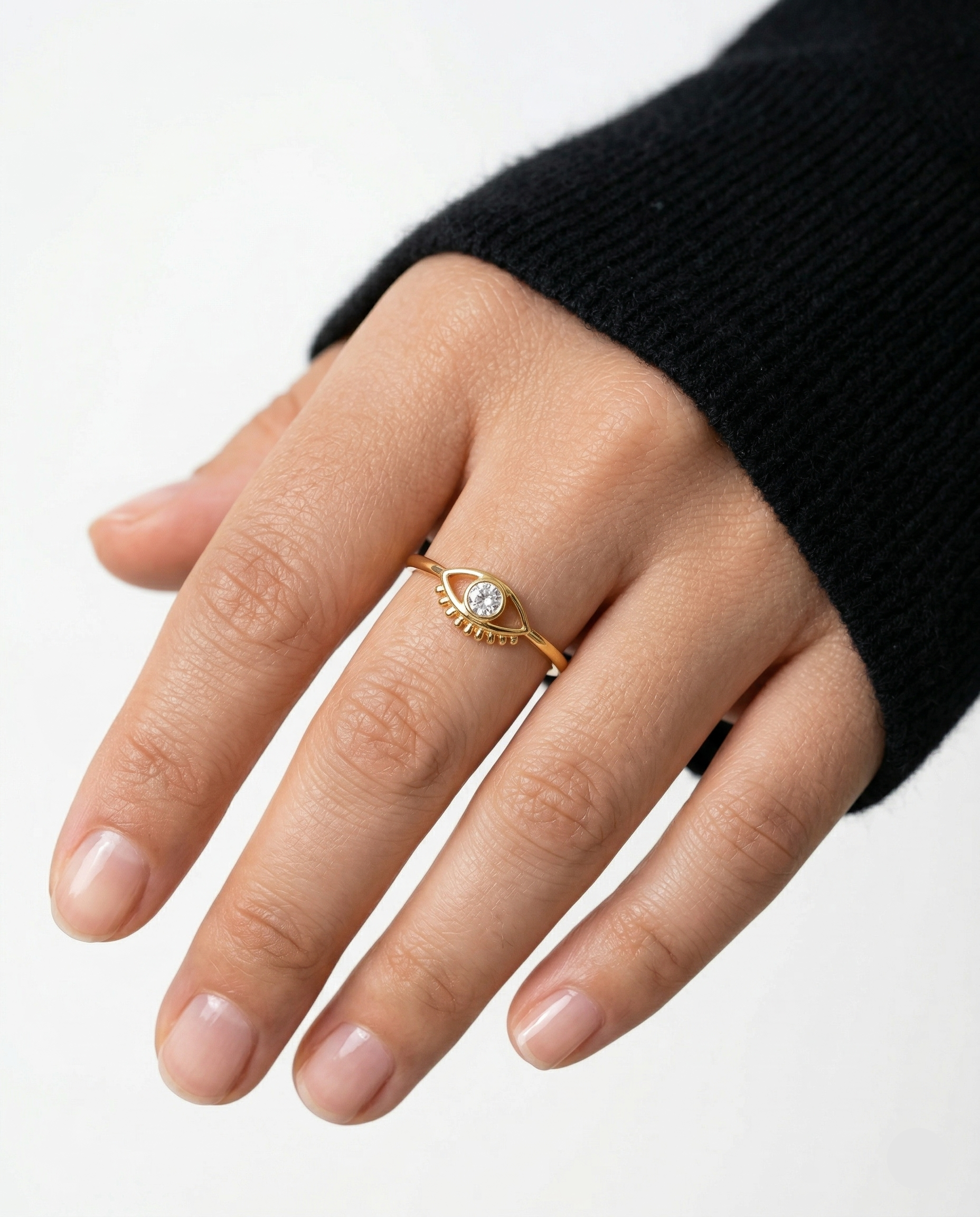 Gold ring with a diamond on a person's finger against a white background