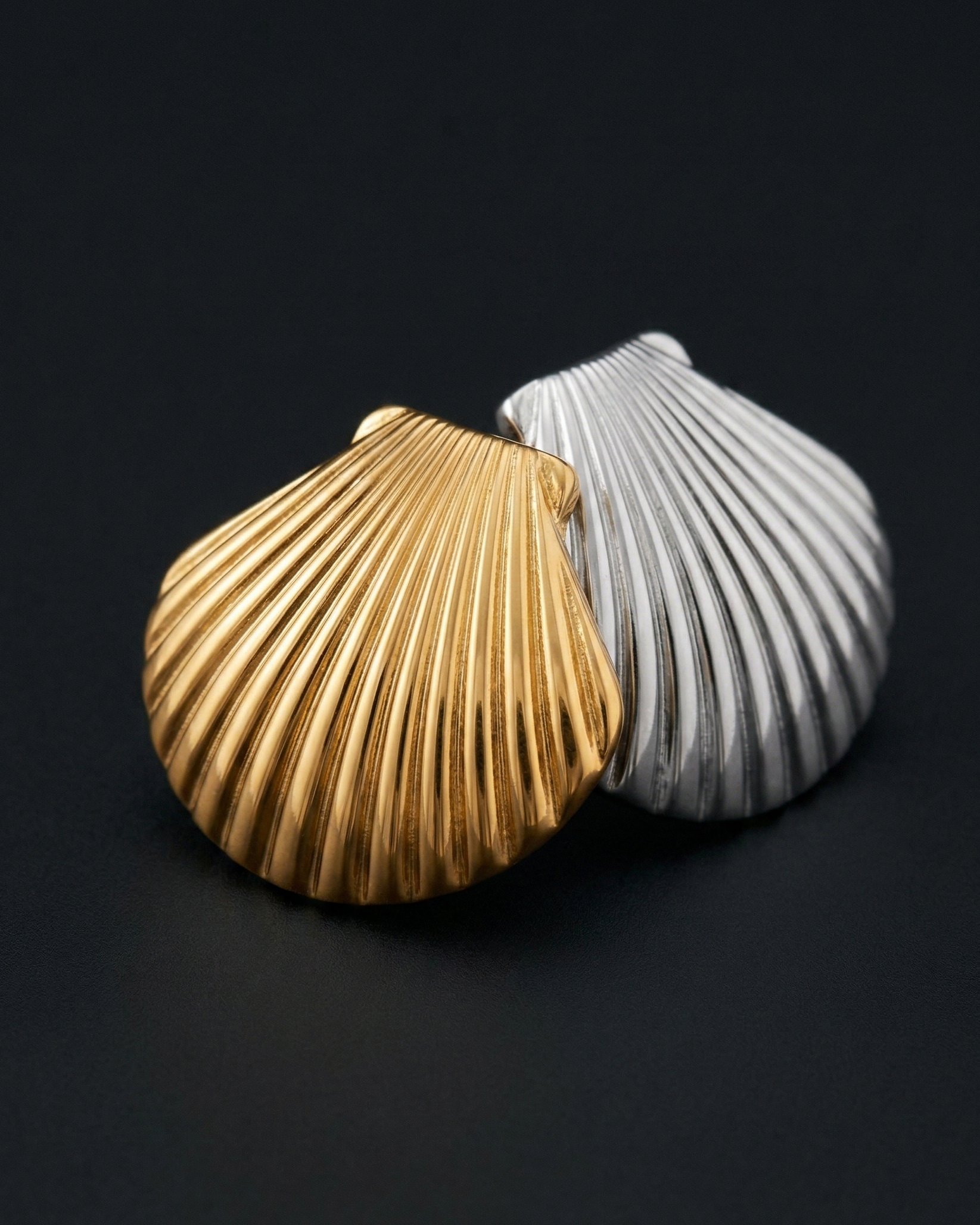 Gold and silver shell-shaped objects on a black background