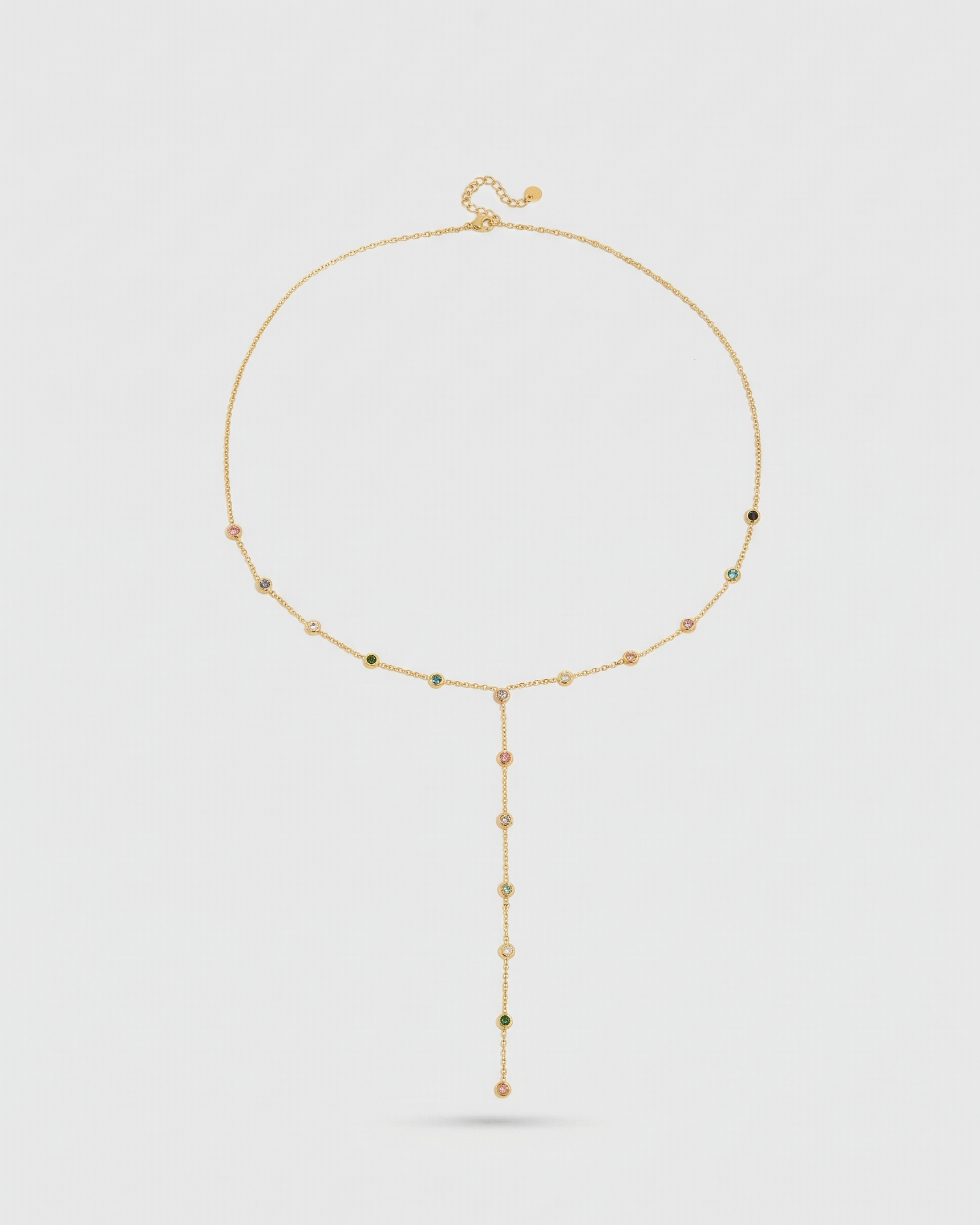 Gold necklace with beads on a light gray background