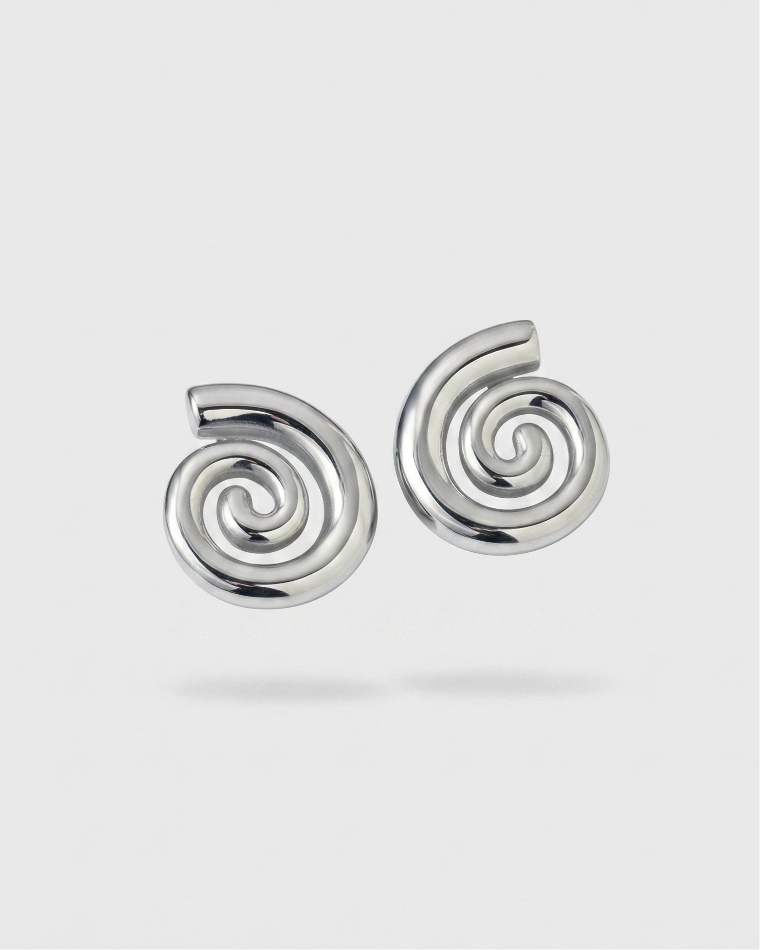 Pair of silver spiral earrings on a light gray background