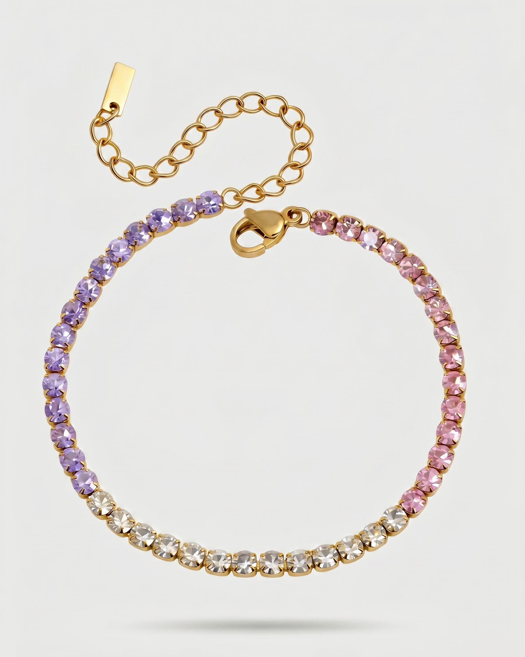 Gold bracelet with multicolored gemstones on a light gray background