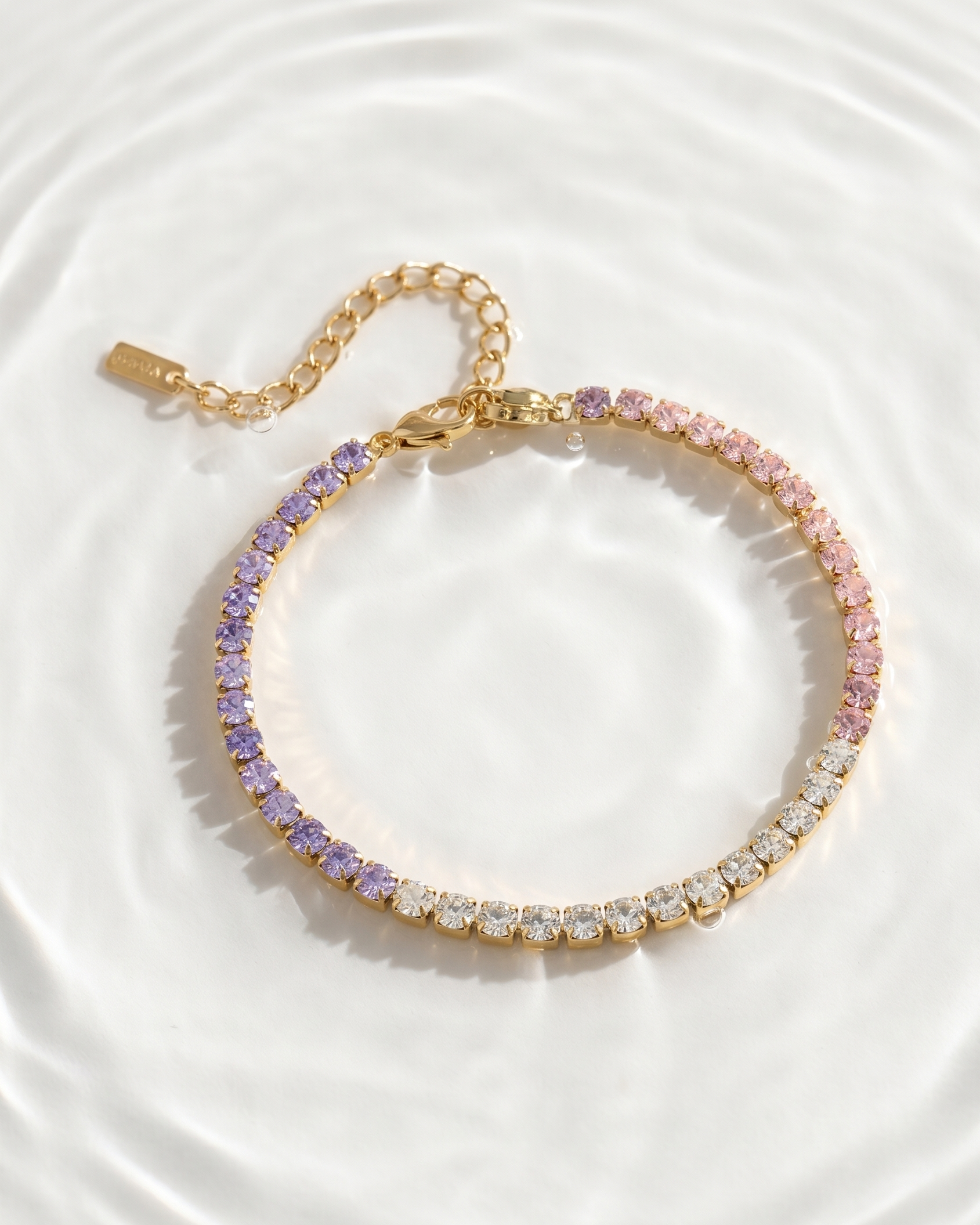 Gold bracelet with multicolored stones on a white background
