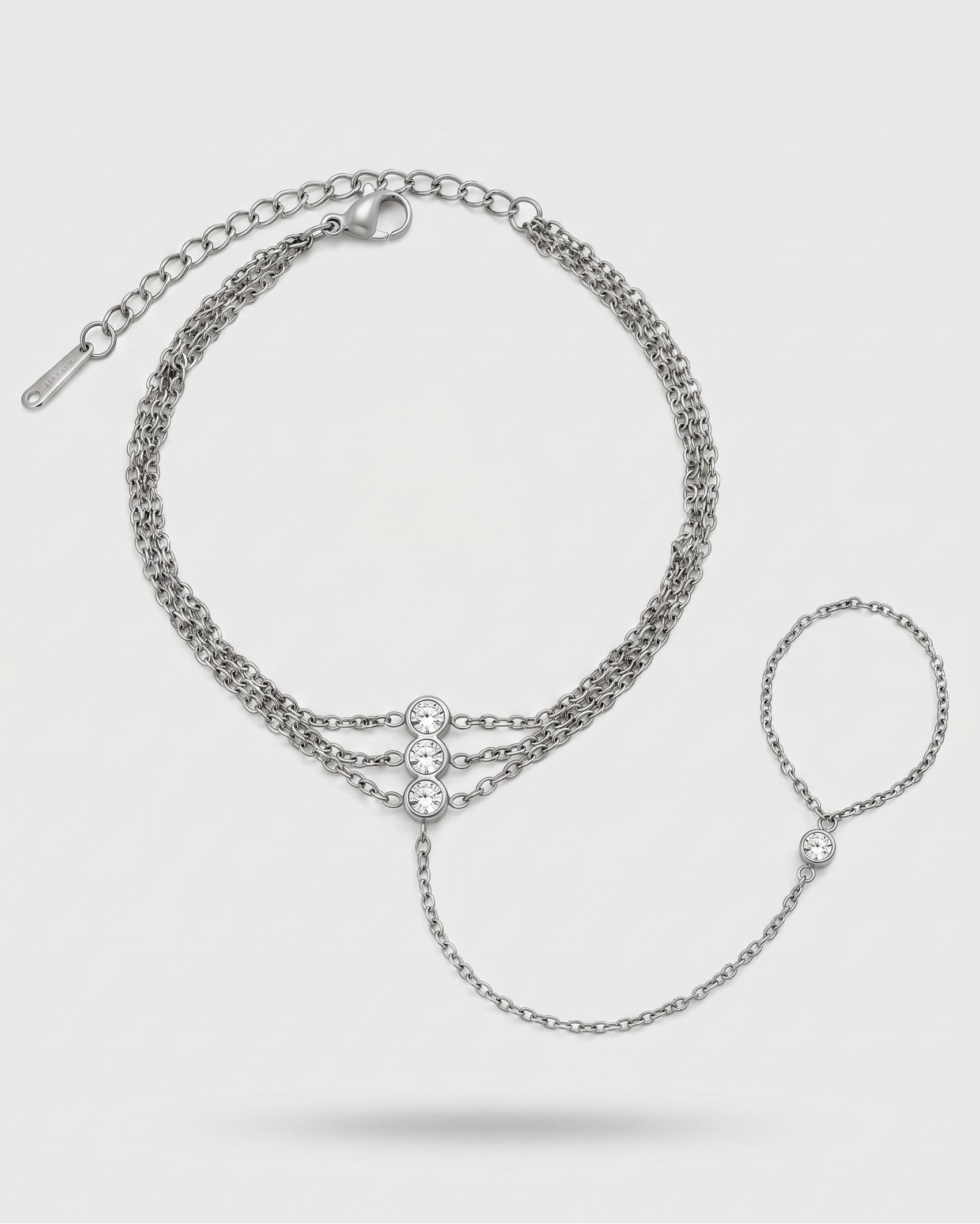 Silver chain bracelet with a heart clasp on a light gray background