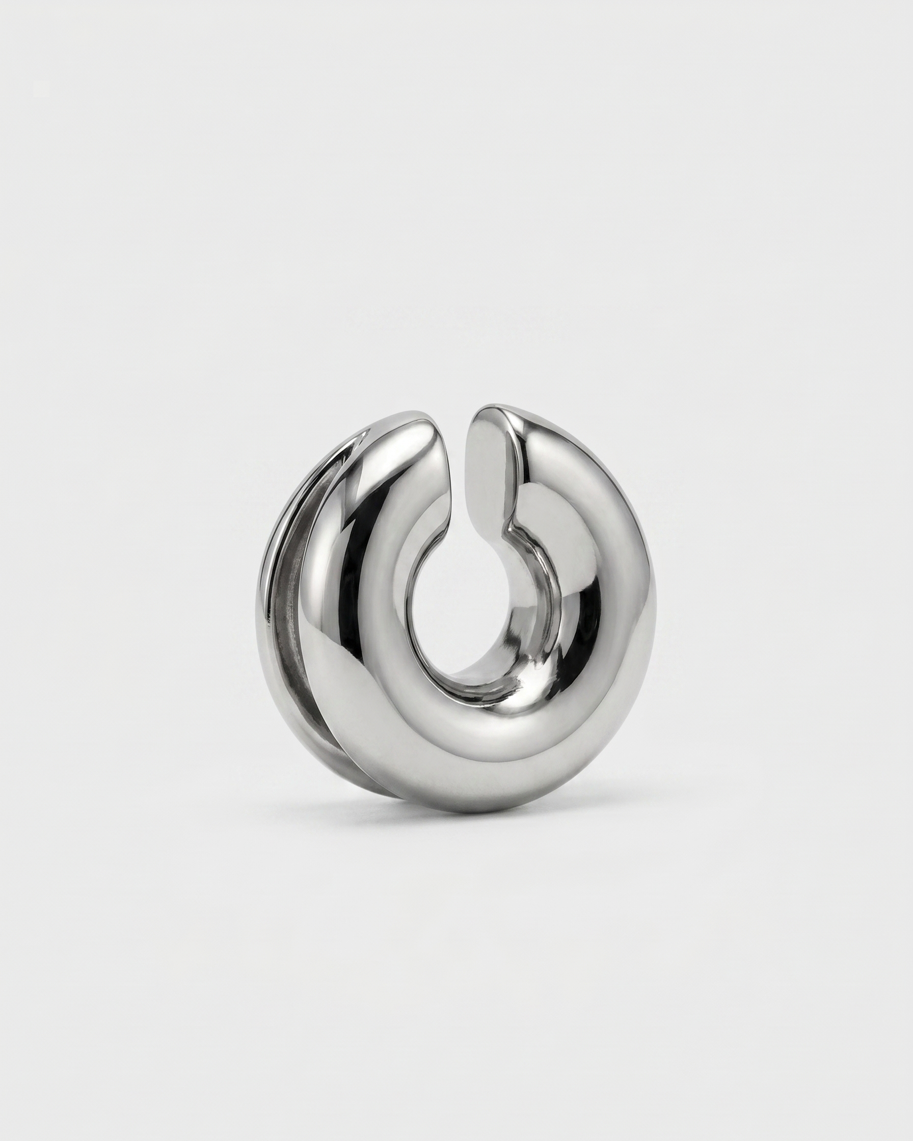 Silver earring on a light gray background