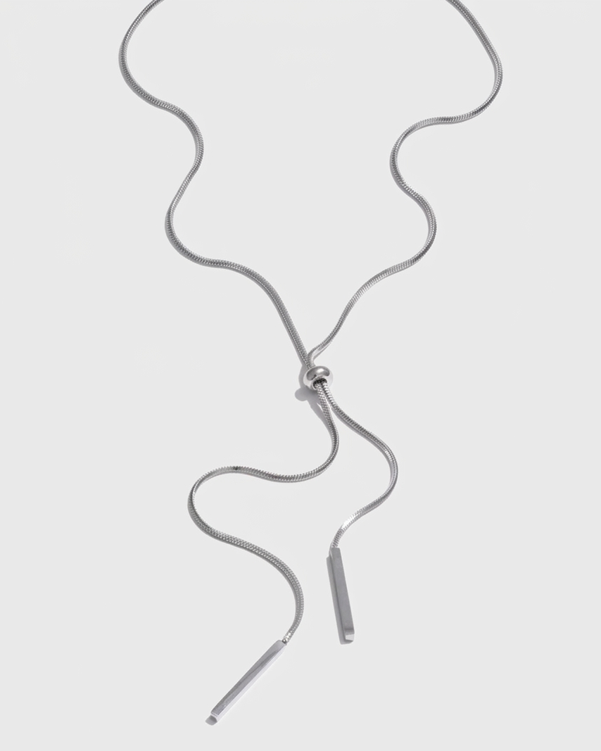 Silver necklace with a small pendant on a light gray background