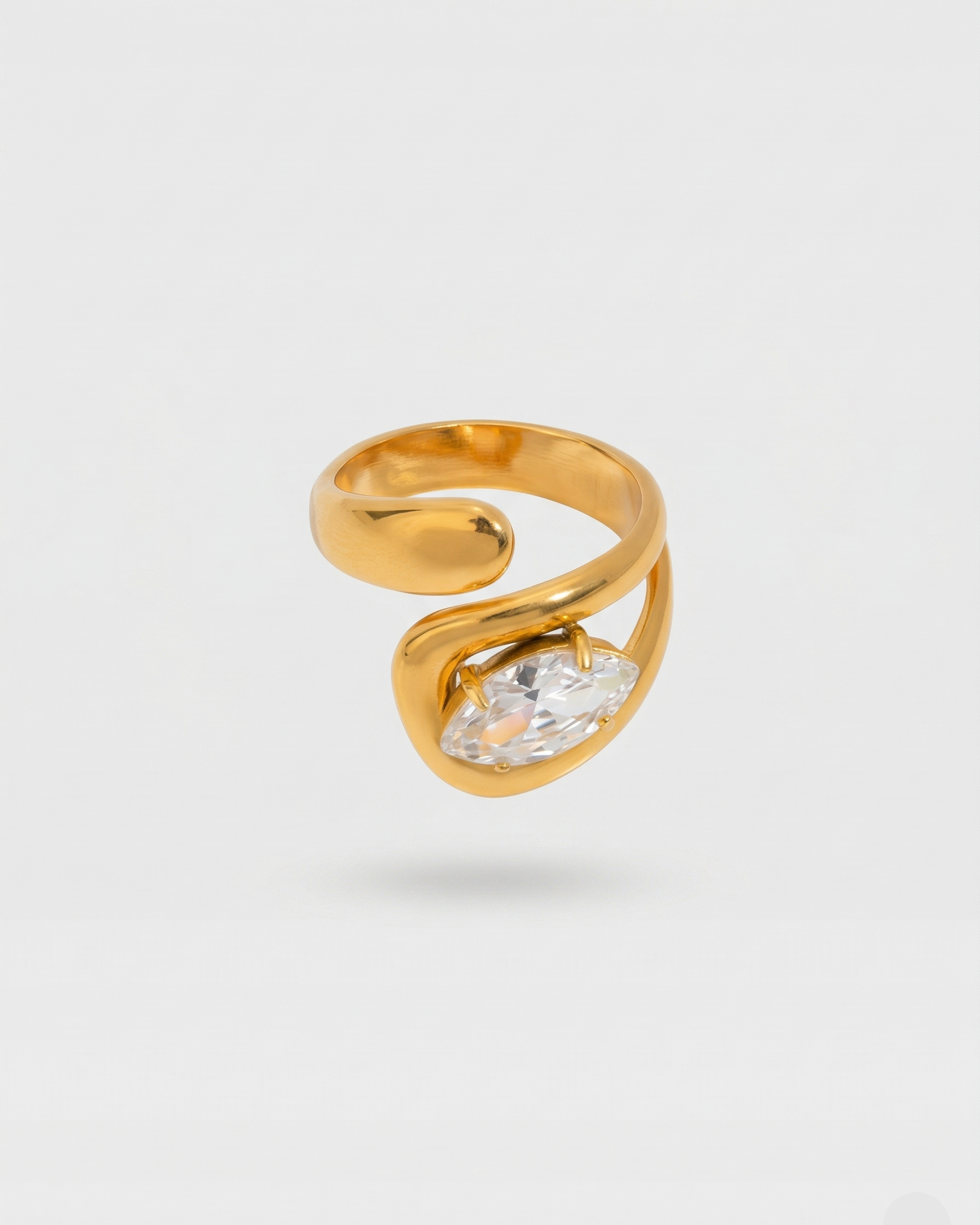 Gold ring with a clear gemstone on a light gray background
