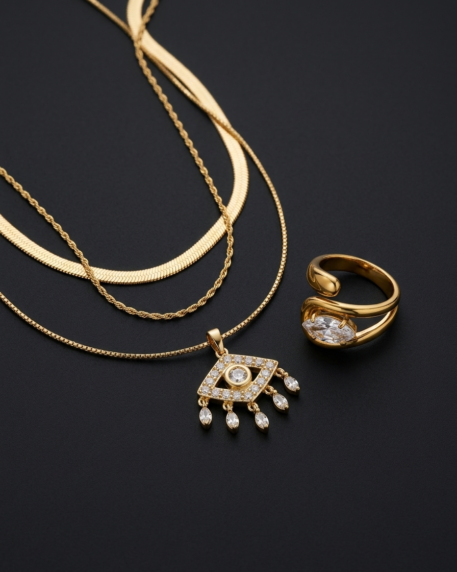 Gold necklace and ring with diamond accents on a black background