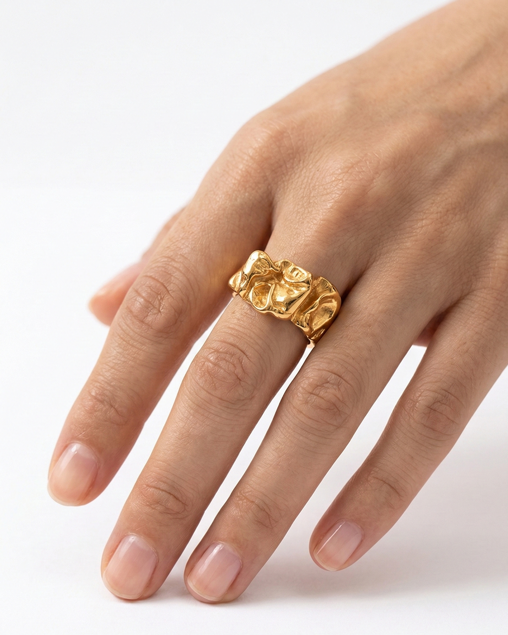 Gold ring on a finger against a white background