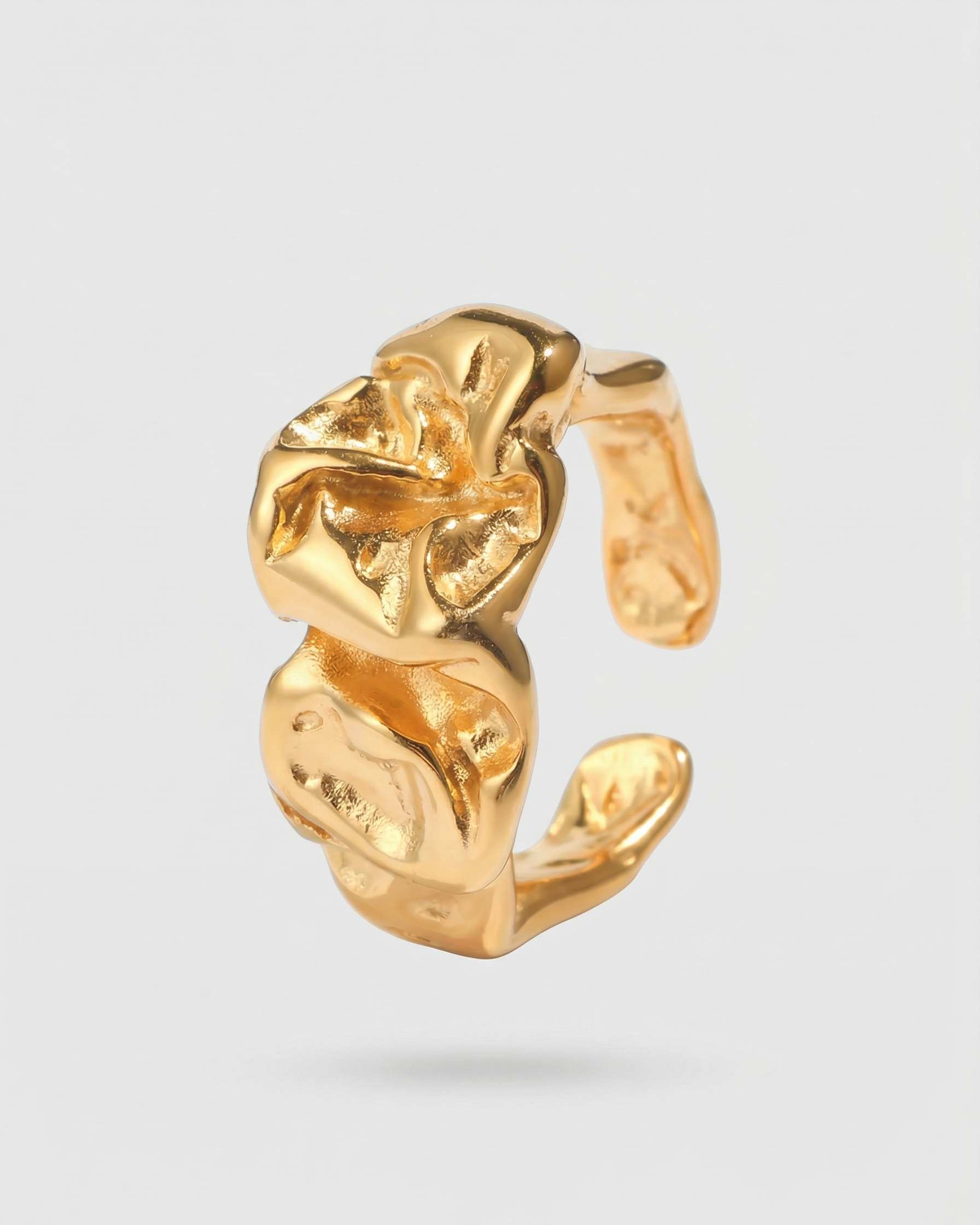 Gold ear cuff on a light gray background