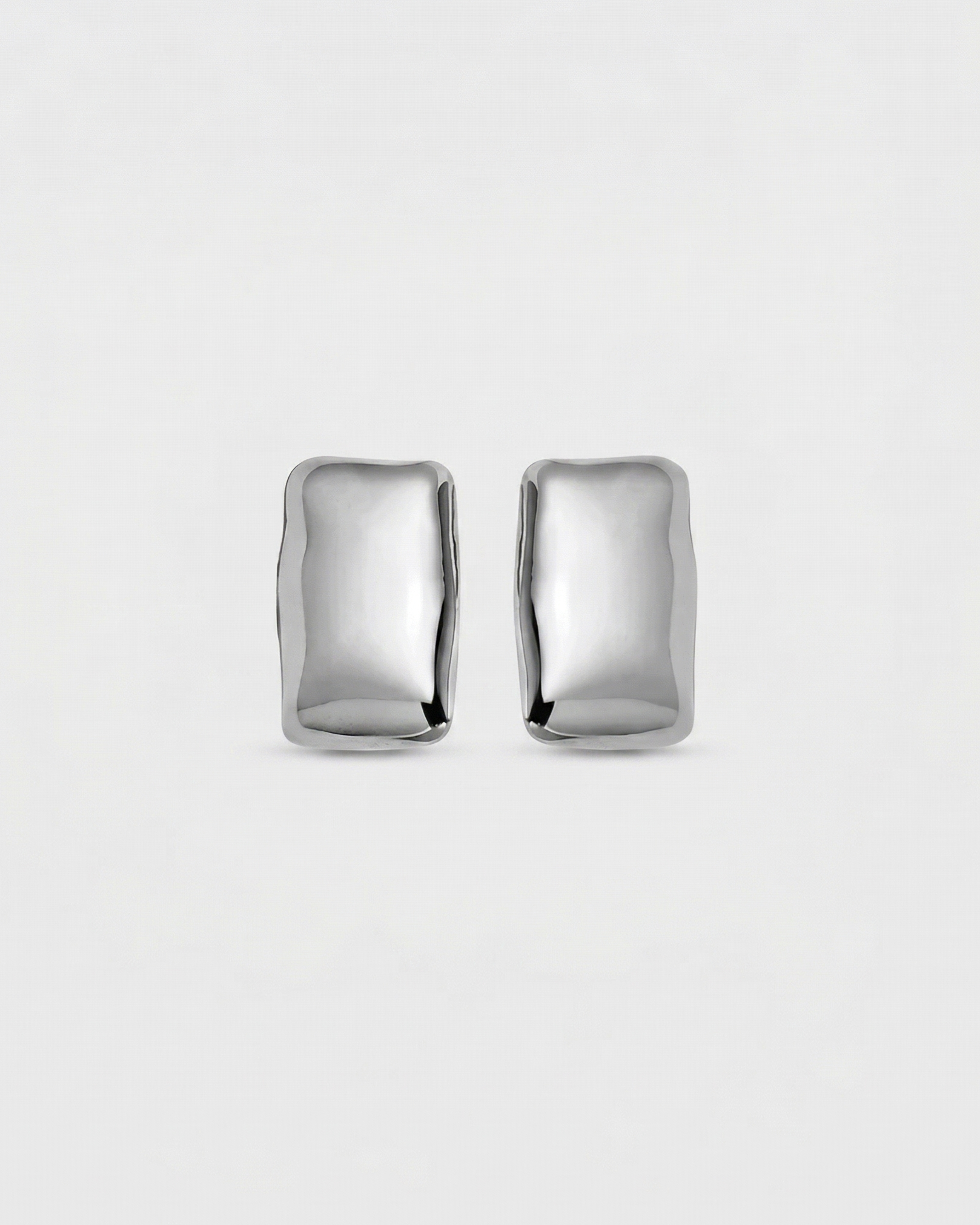 Pair of silver earrings on a light gray background