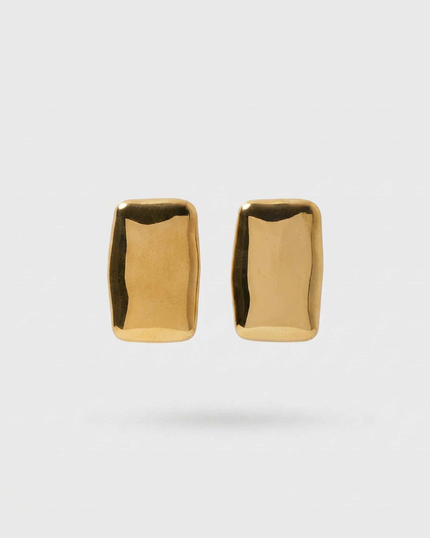 Pair of gold earrings on a light gray background