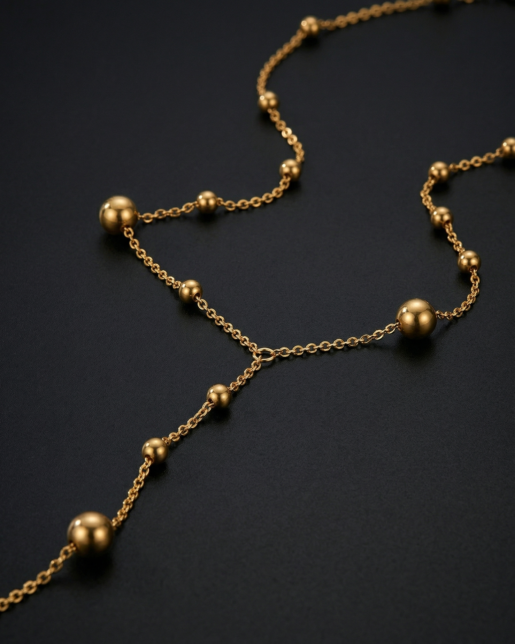 Gold necklace with spherical beads on a dark background