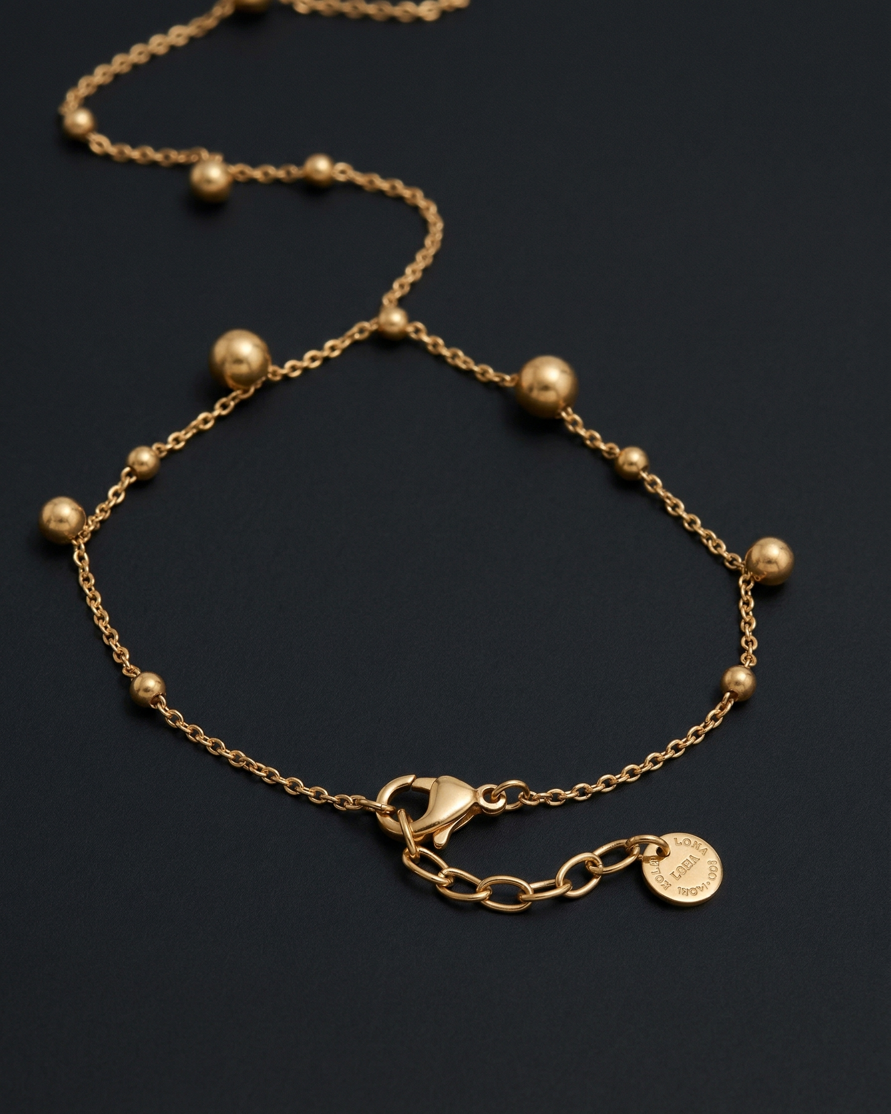 Gold bracelet with beads on a dark background